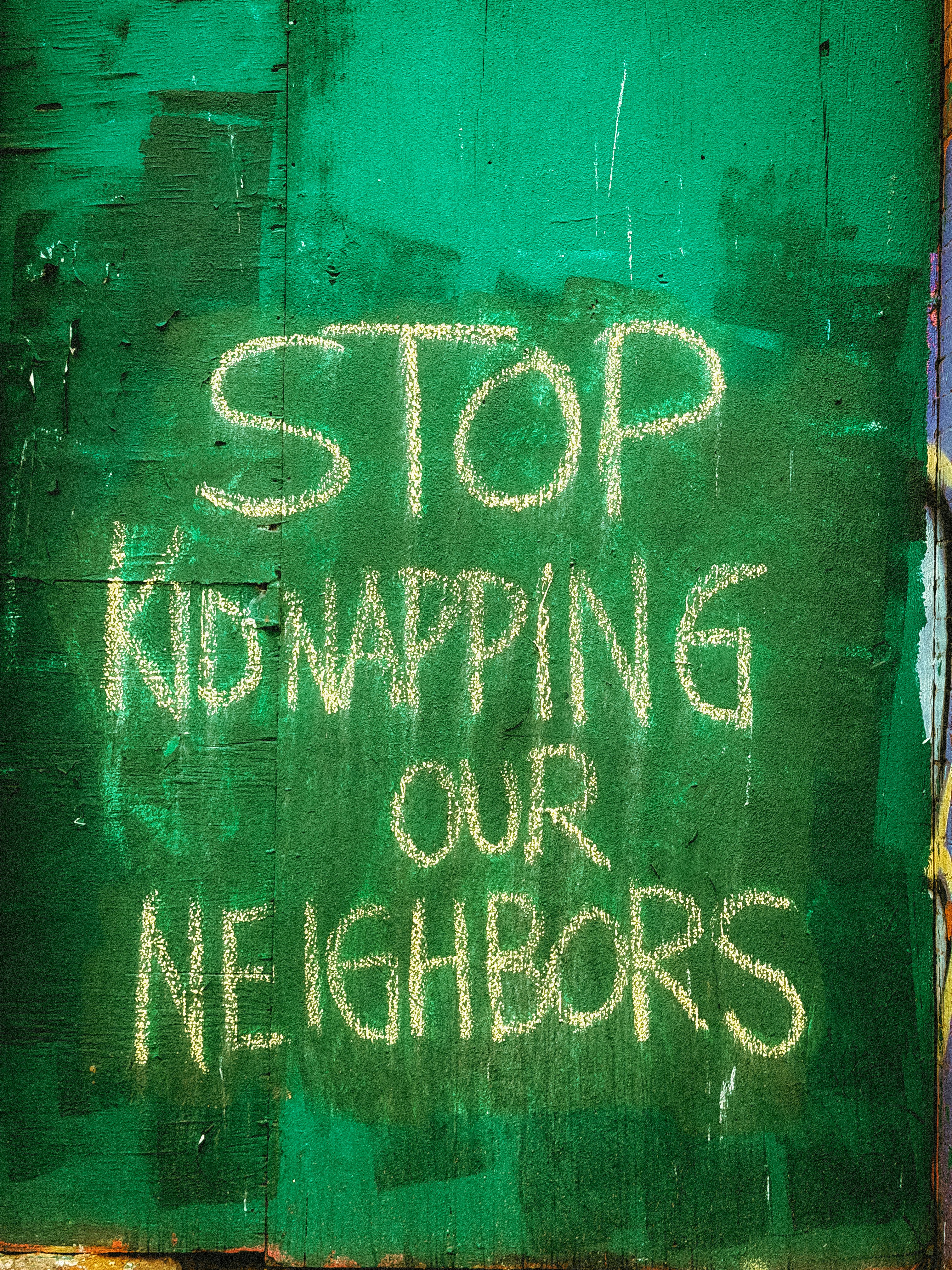Stop kidnapping our neighbors message on wall