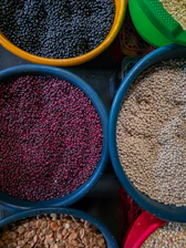 Bowls of assorted dried beans and grains.