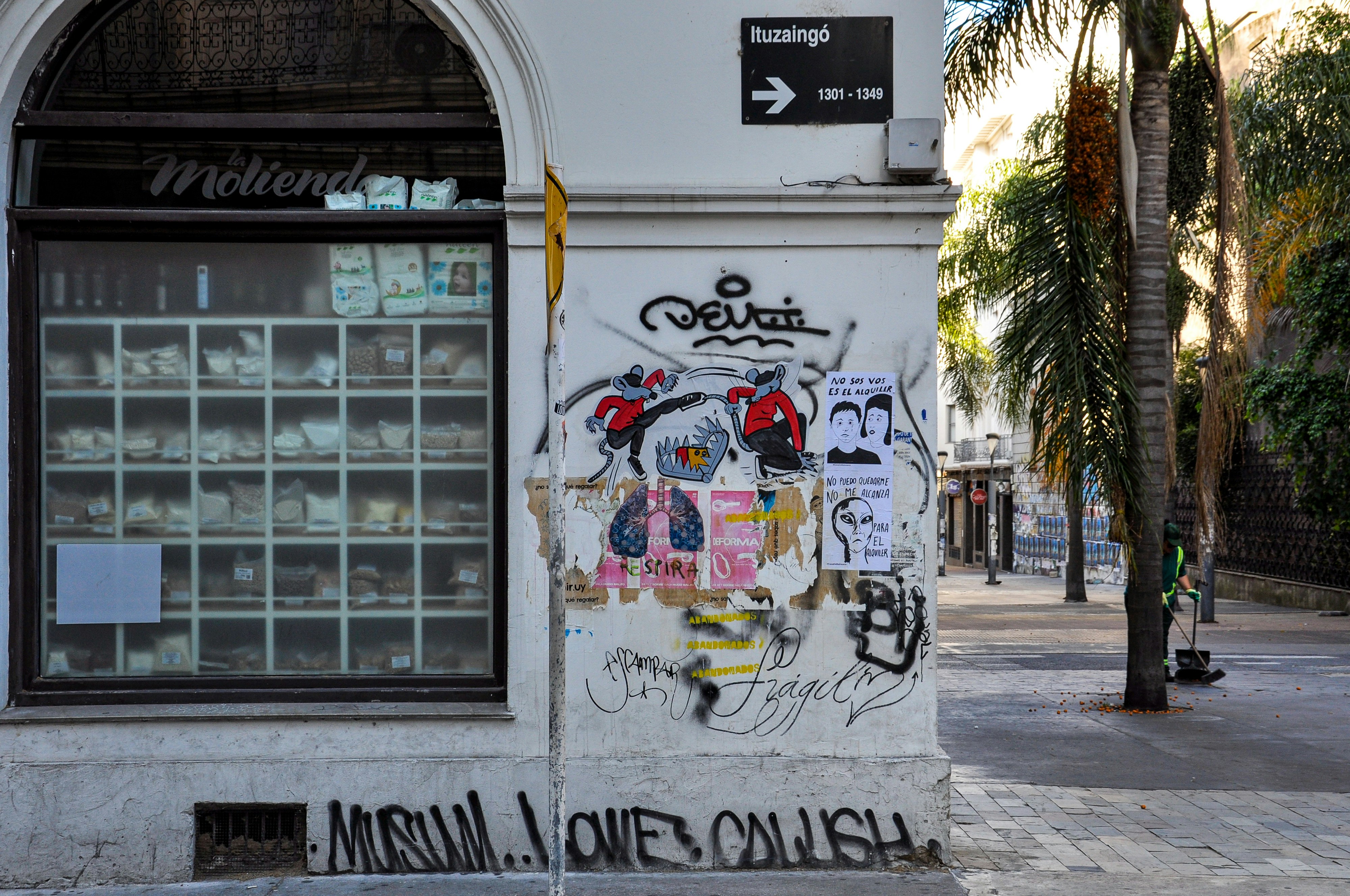 Graffiti art adorns a building wall next to a storefront.