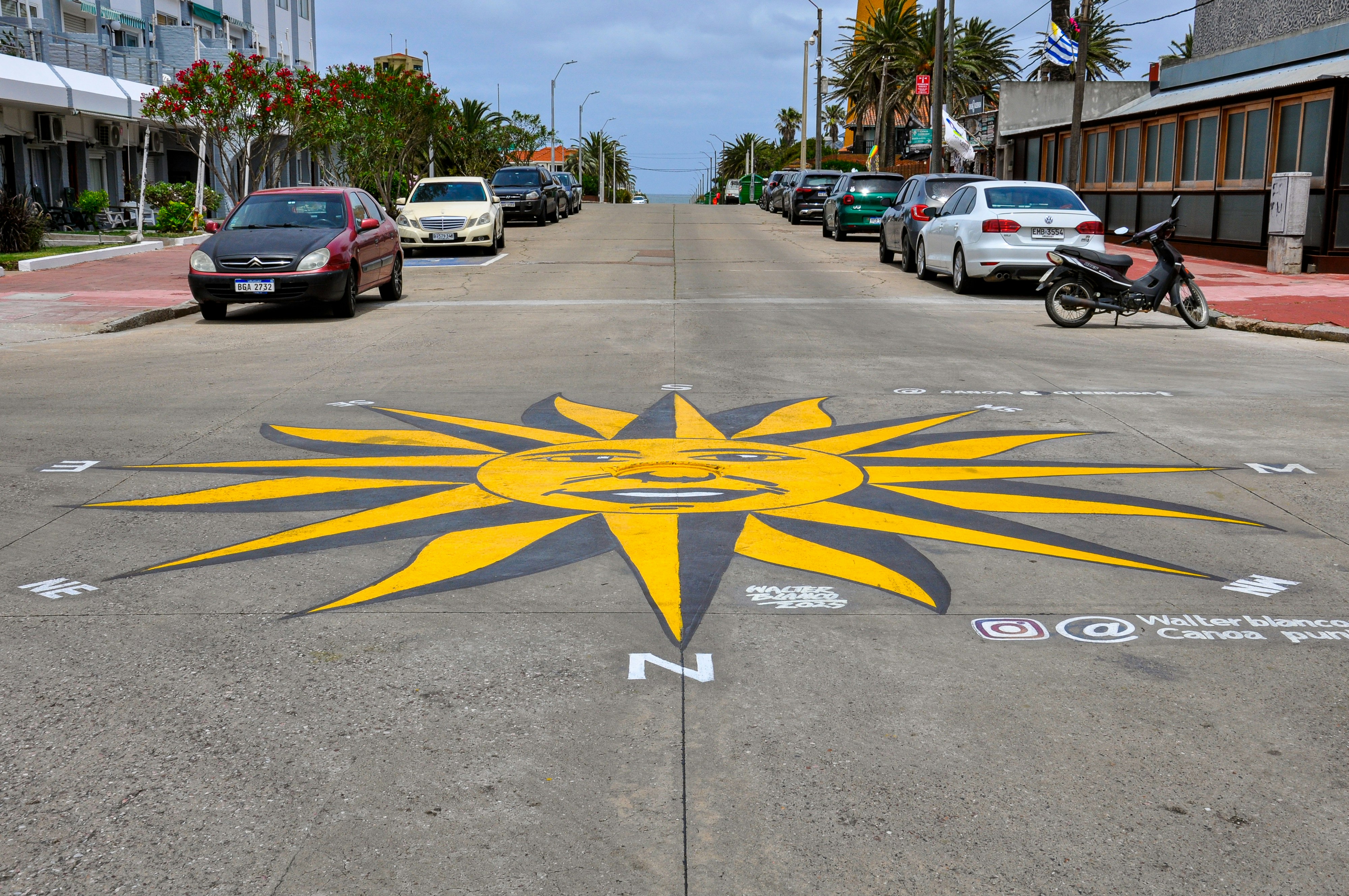 Sun compass painted on a street with cars.