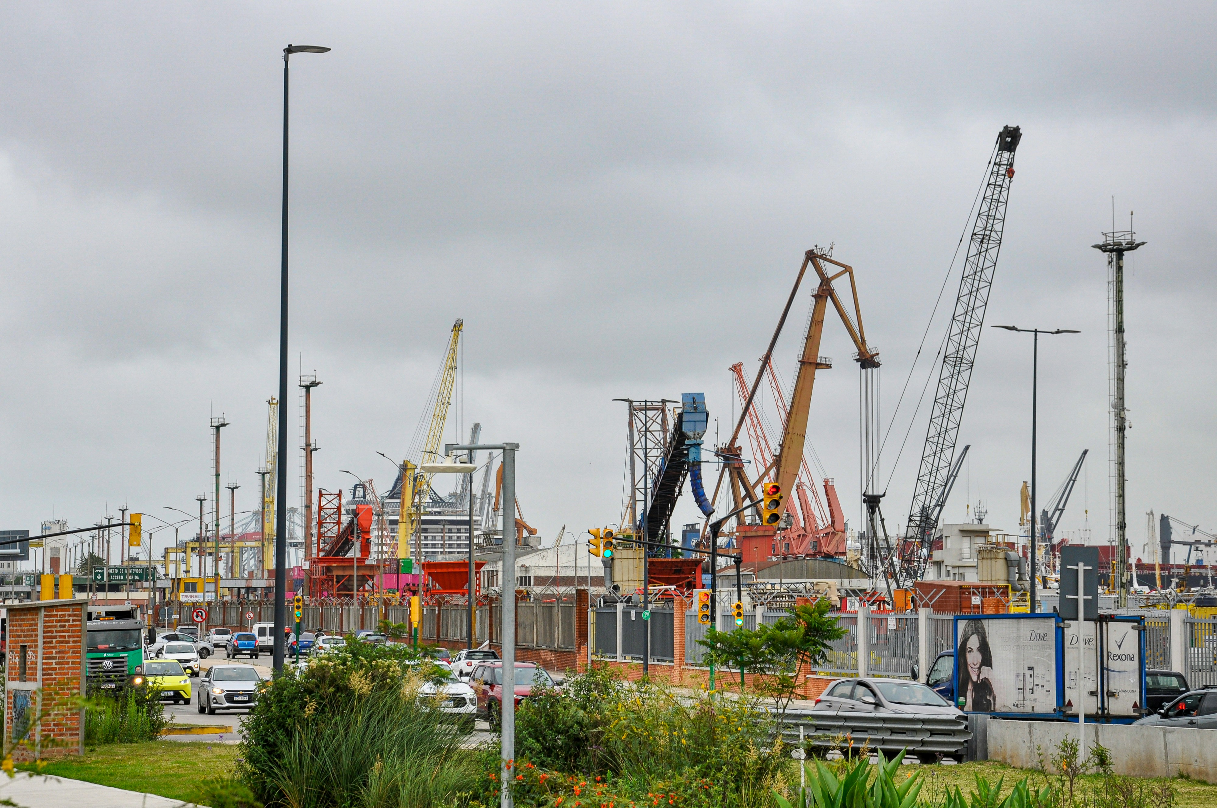 Industrial port with many cranes under a cloudy sky