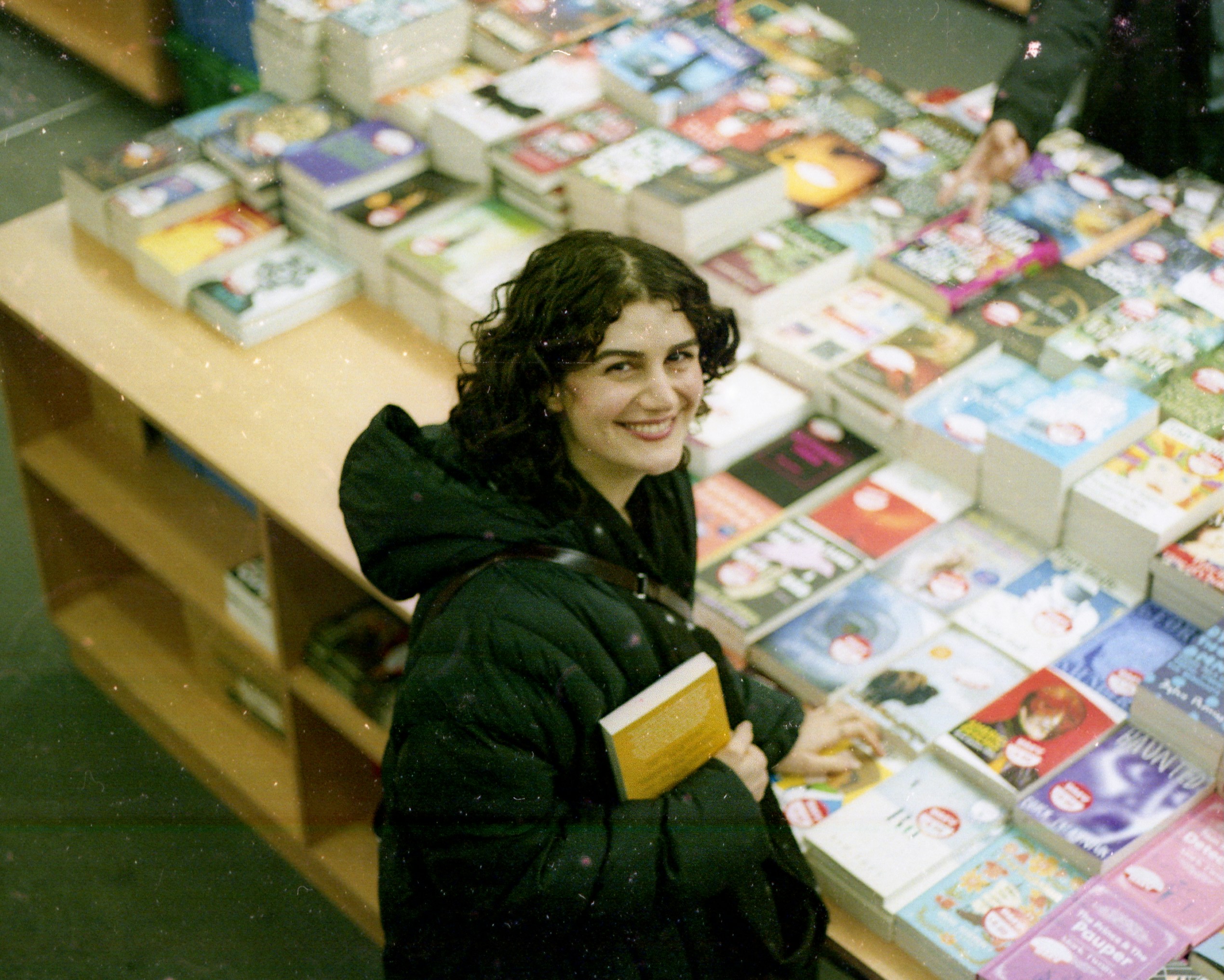 Woman smiling at a table full of books