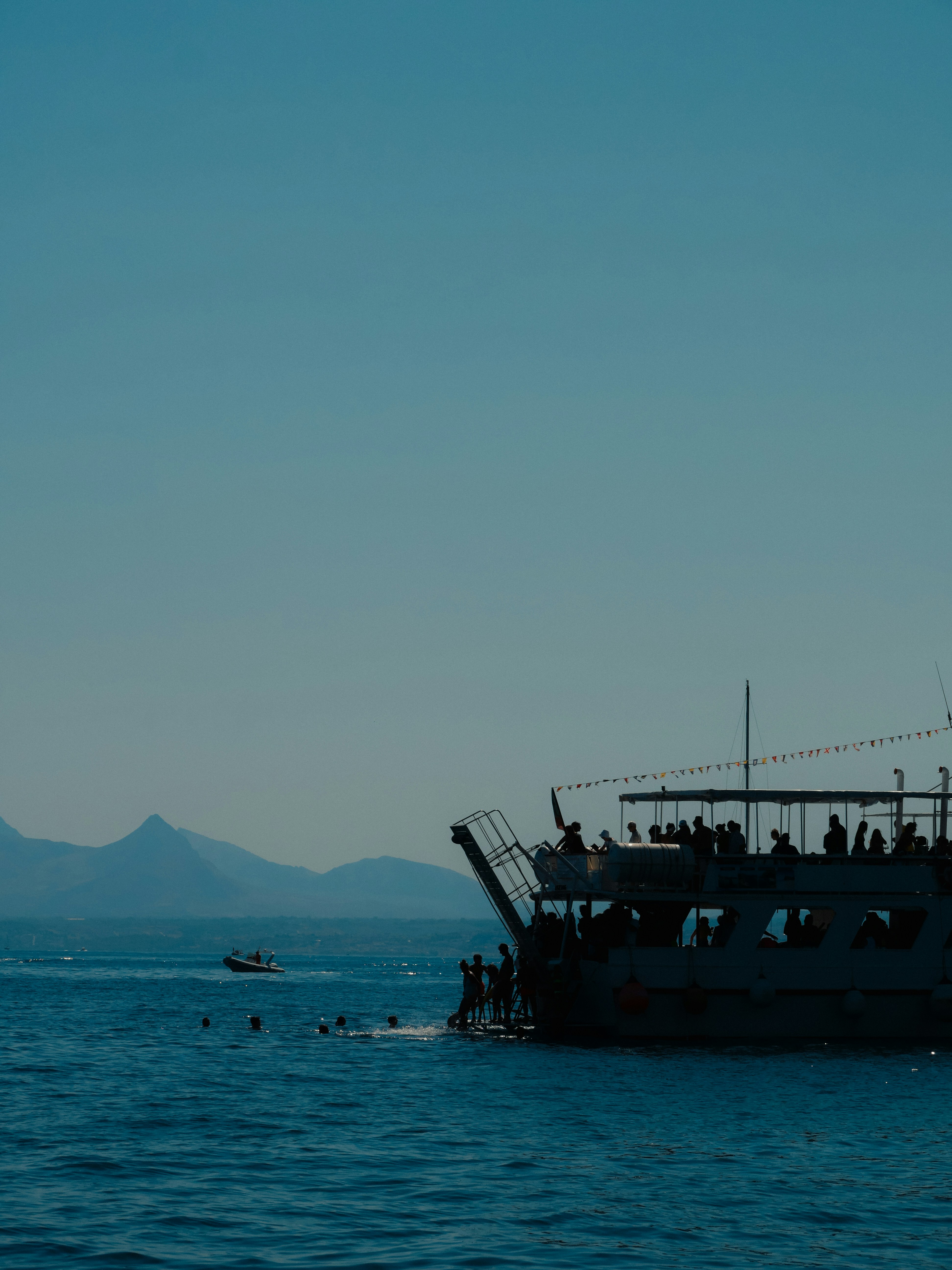 People on a boat with mountains in the distance.