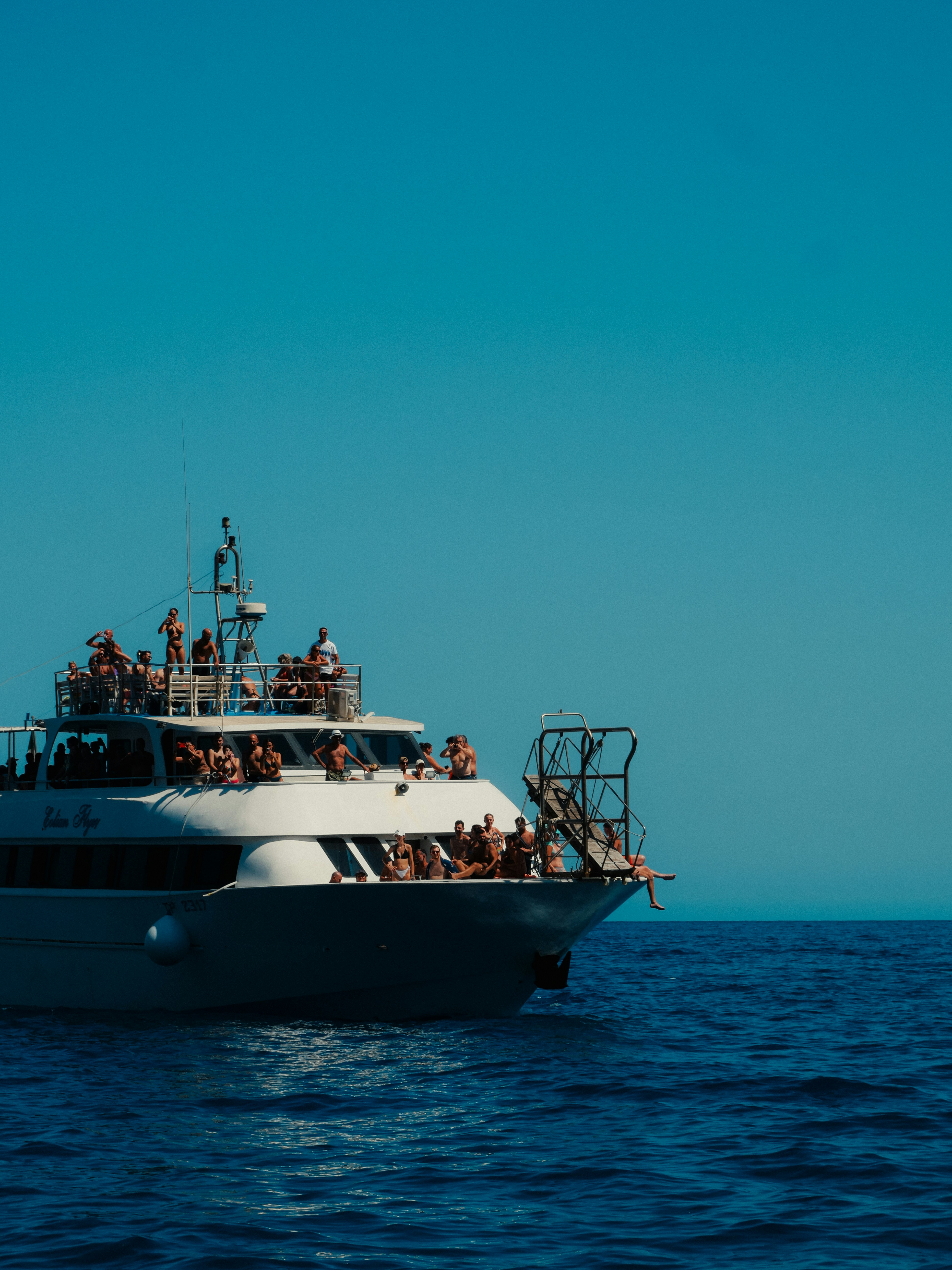 Tour boat filled with people sailing on the ocean.