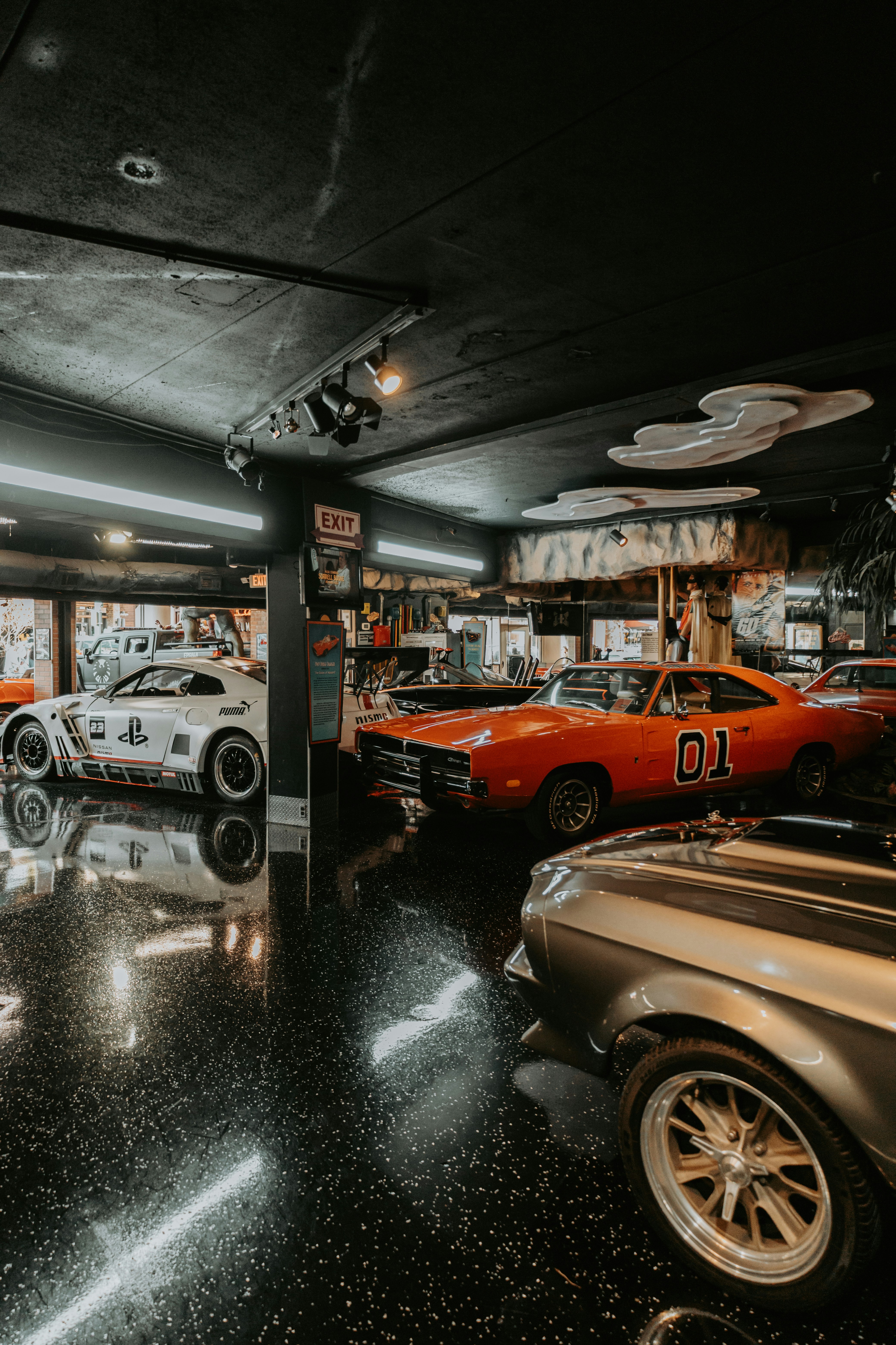 Sammlung von klassischen und modernen Autos, die im Innenraum ausgestellt sind.