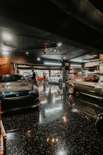 Several classic cars parked inside a garage.