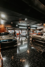 Several classic cars parked inside a garage.