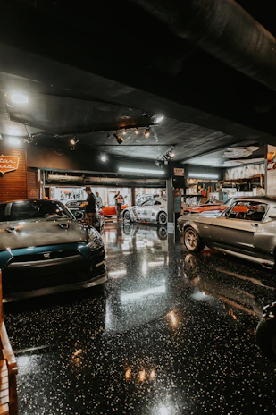 Several classic cars parked inside a garage.
