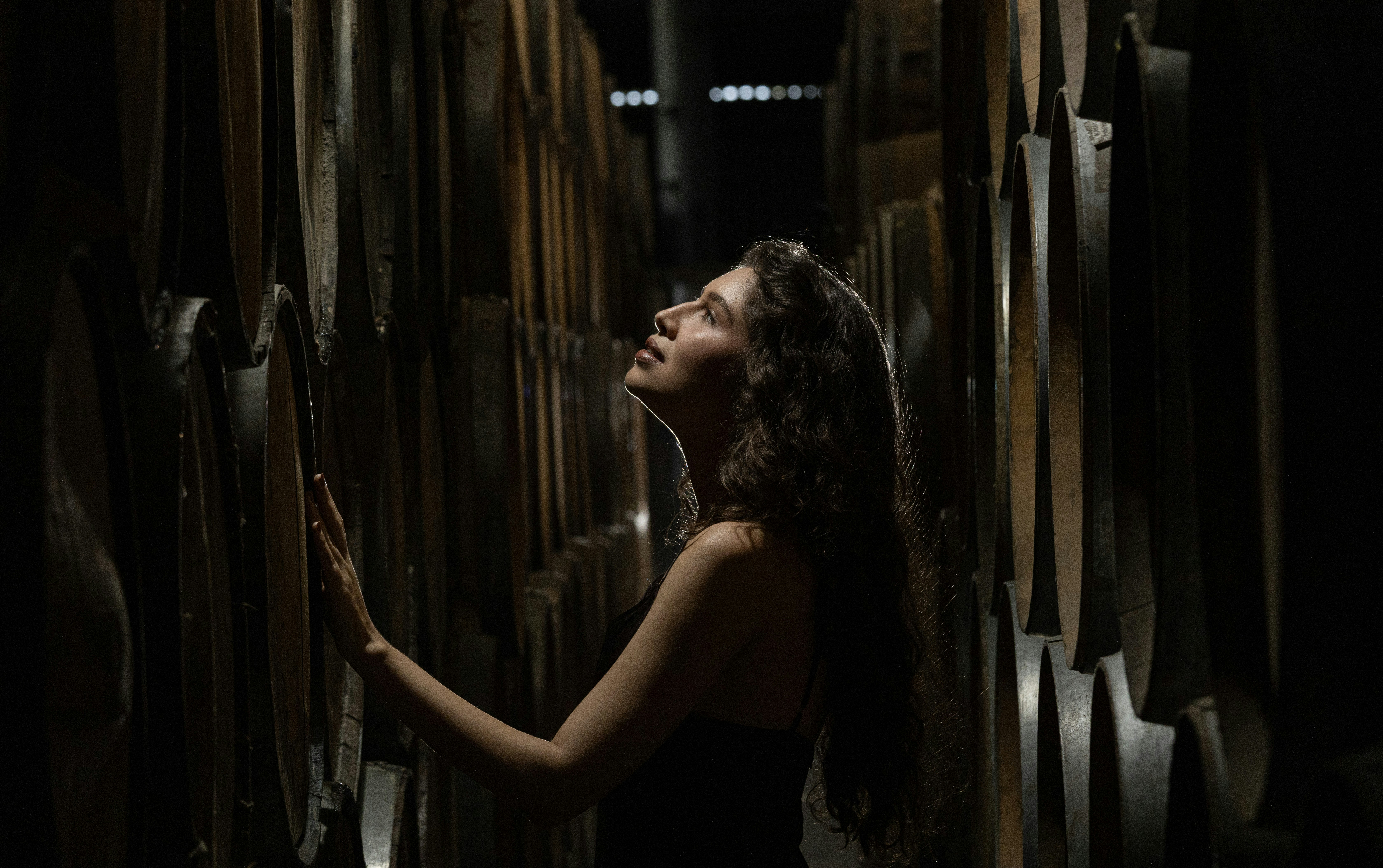 Woman looking up among stacked barrels