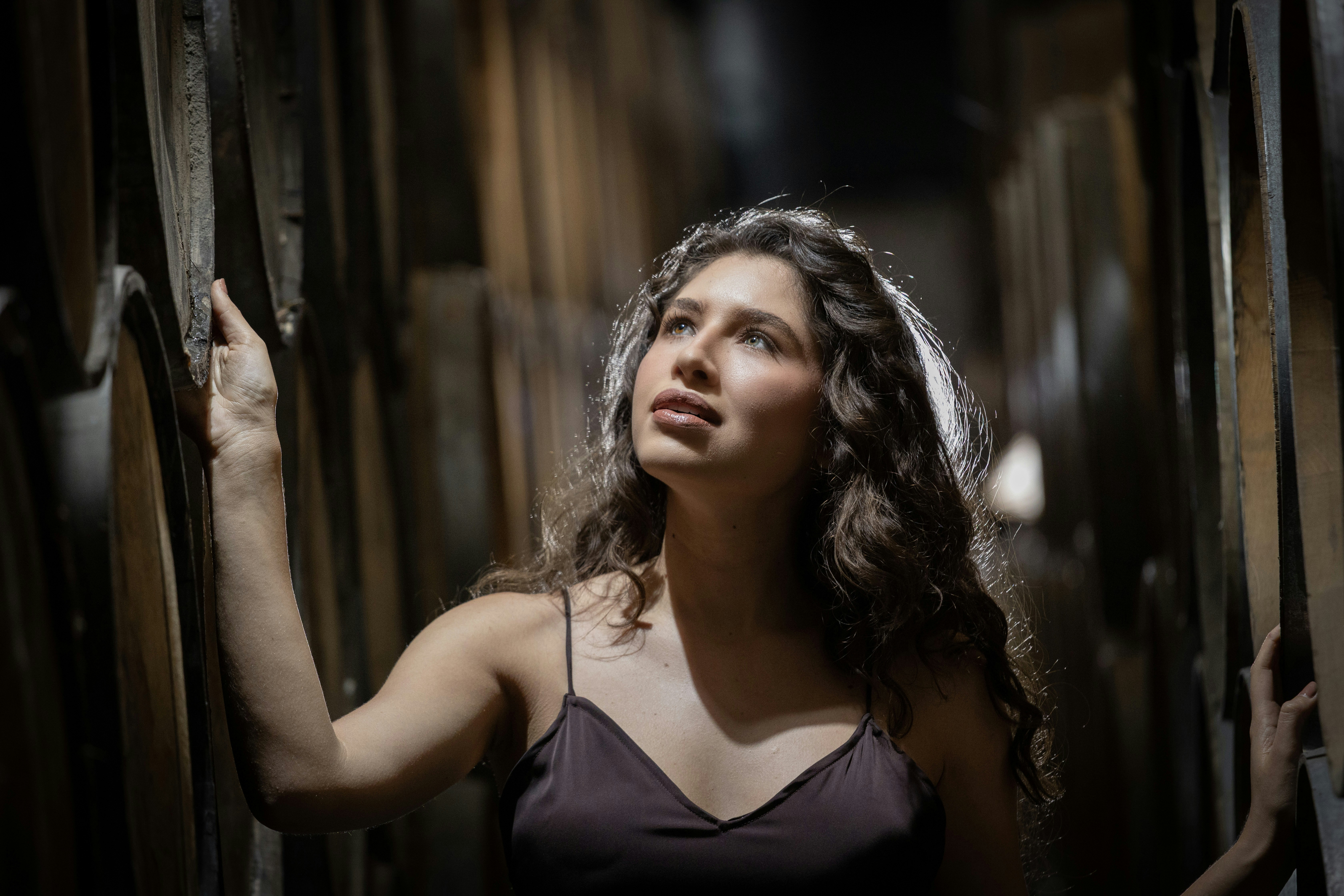 Young woman looking up in a dimly lit space