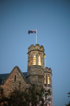 Stone castle tower with flag against twilight sky