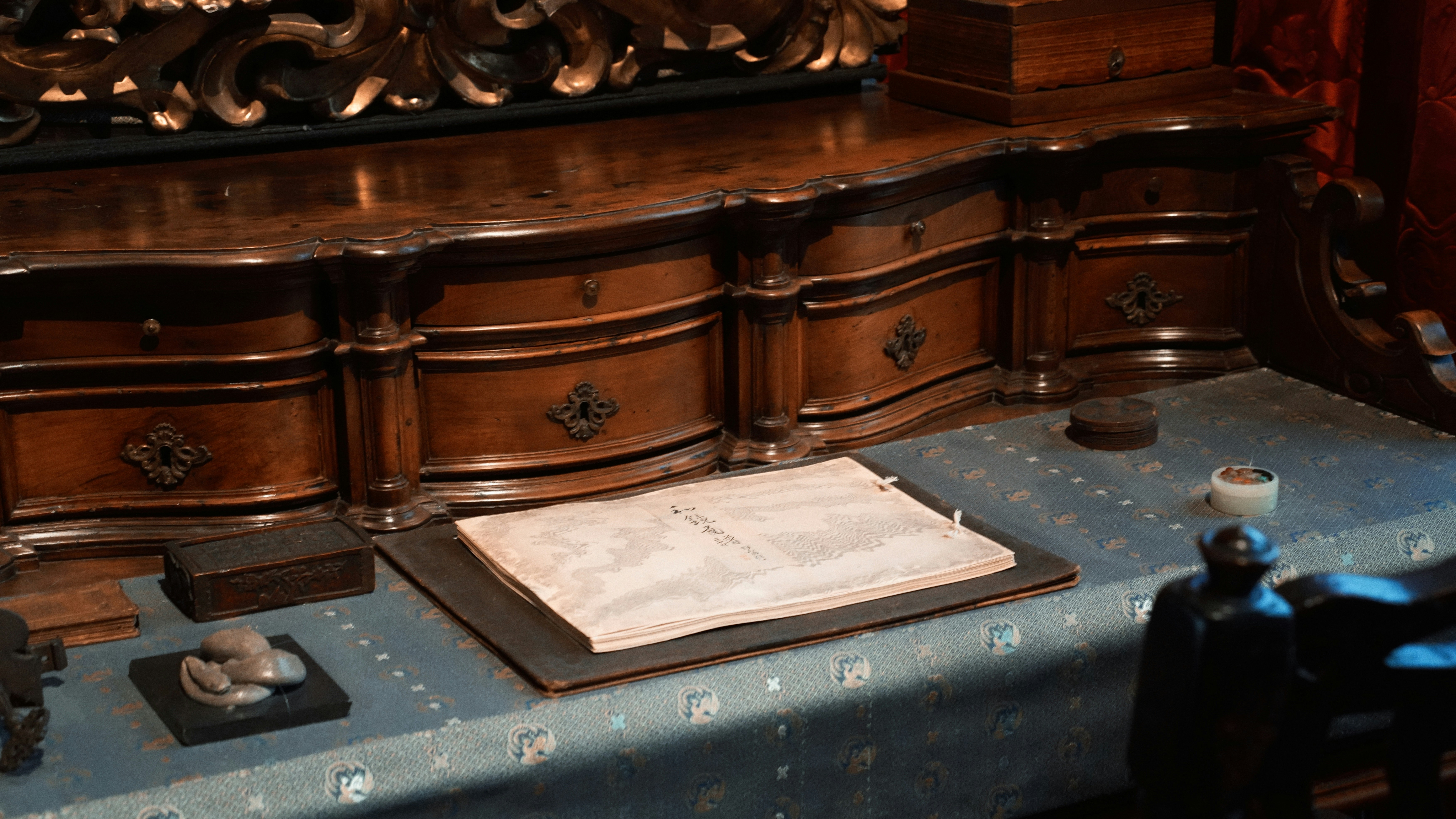 An antique desk with papers and writing tools