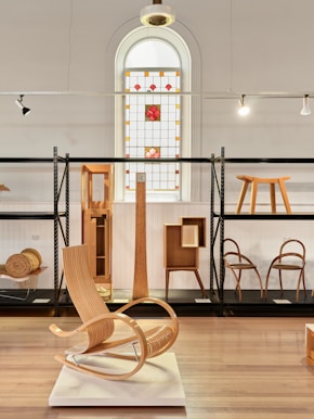 Wooden furniture displayed in a museum exhibition.