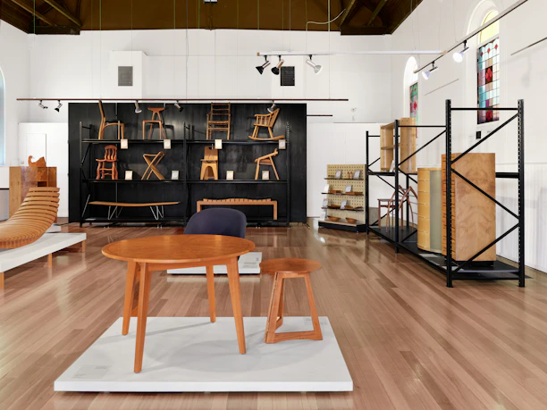 Wooden furniture displayed in a modern gallery setting