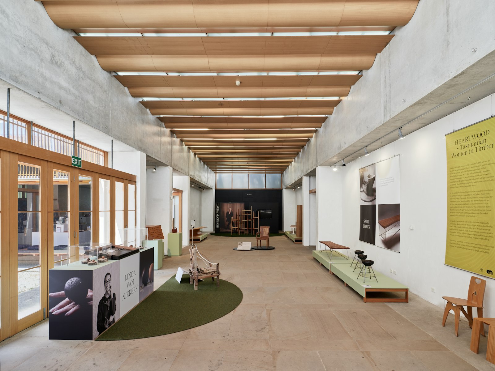 Bright exhibition space with low display plinths, wall panels and a tall printed banner