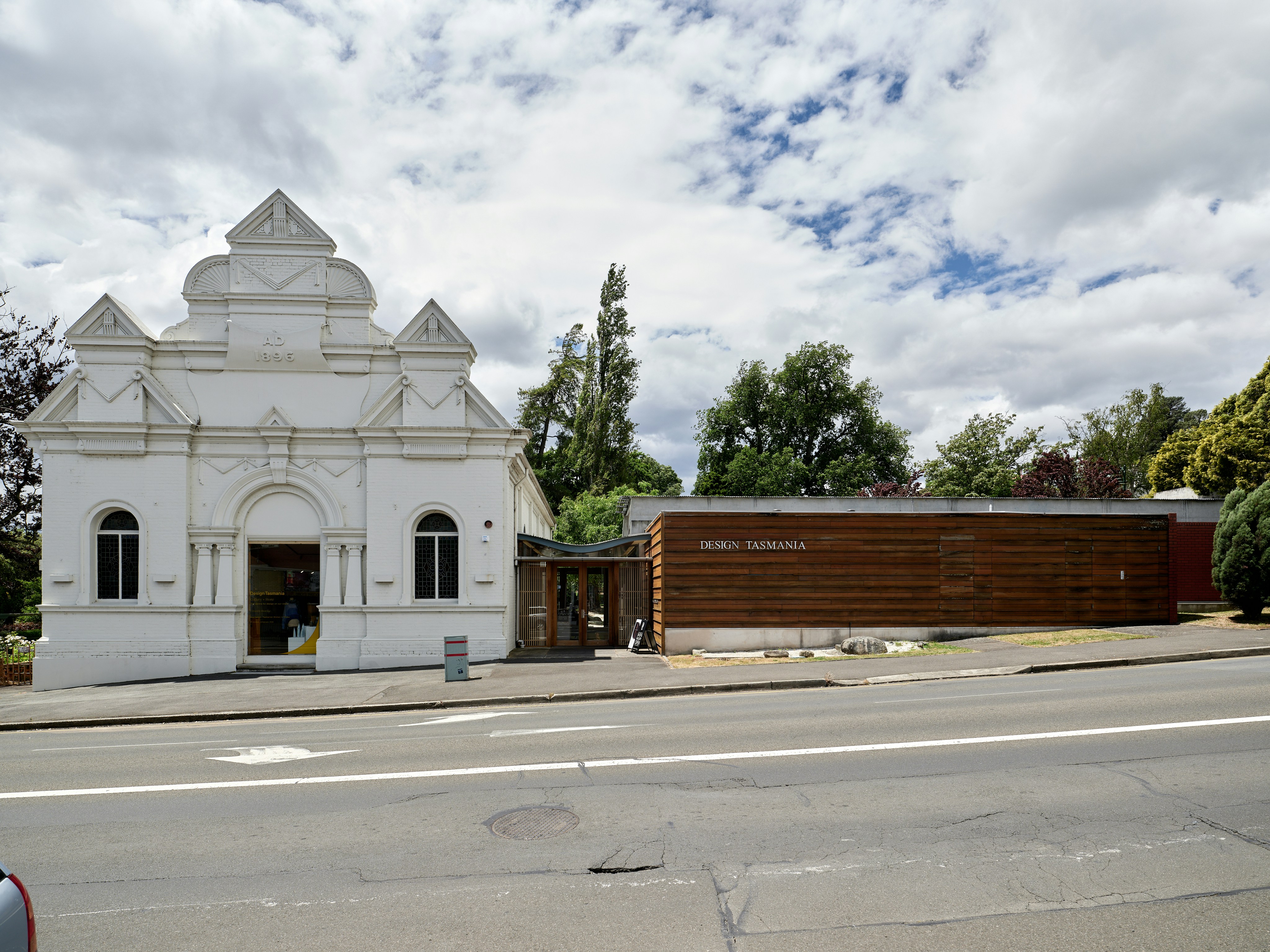 White ornate building next to modern wooden structure.