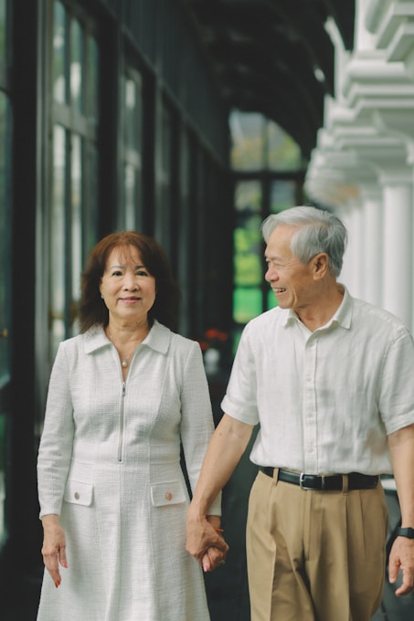 Elderly couple holding hands while walking