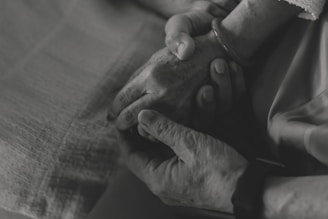 Two hands gently holding each other in comfort.