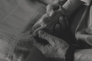 Two hands gently holding each other in comfort.