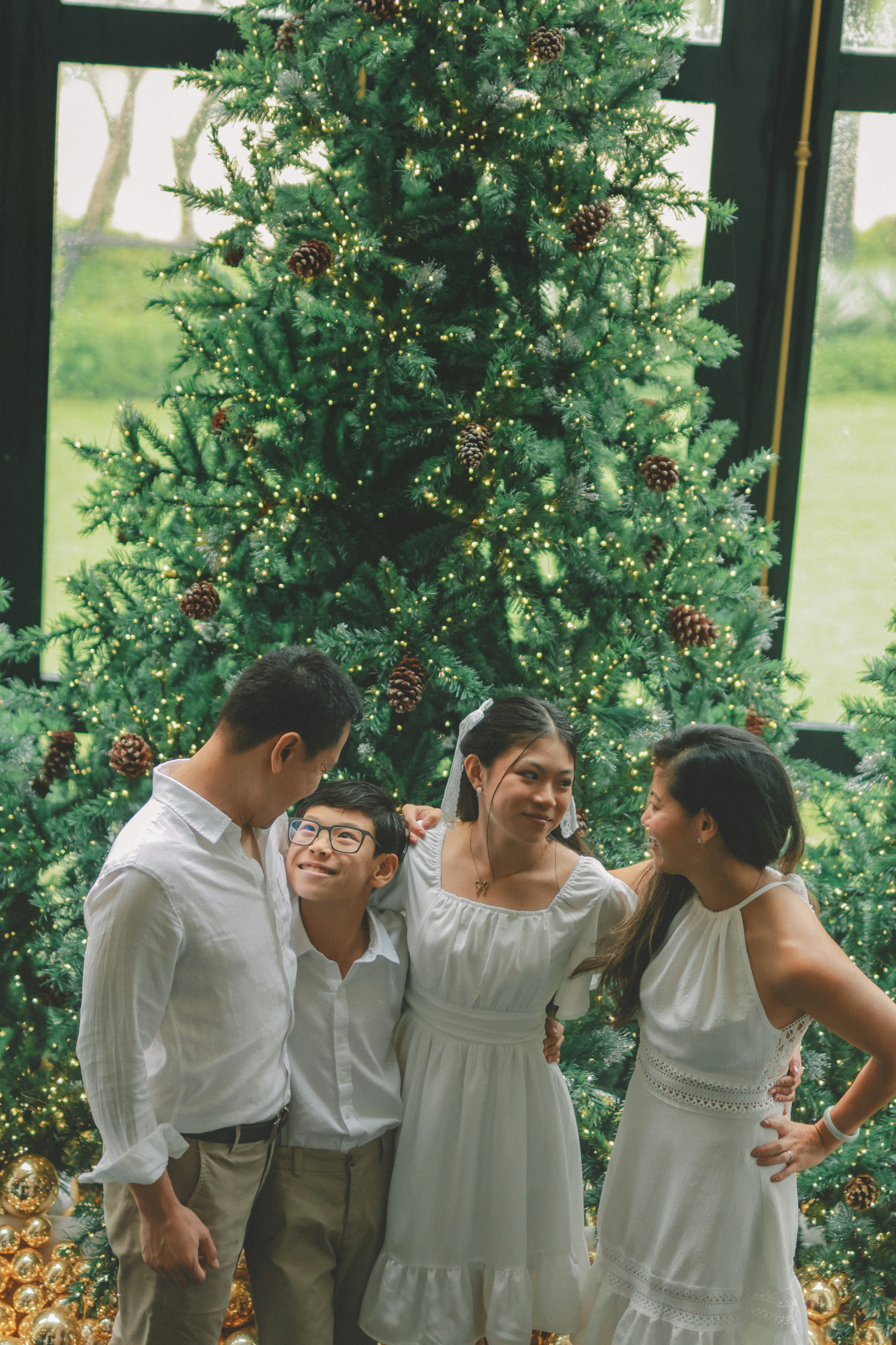 Family posing in front of a decorated christmas tree