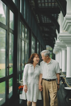 Elderly couple holding hands while walking
