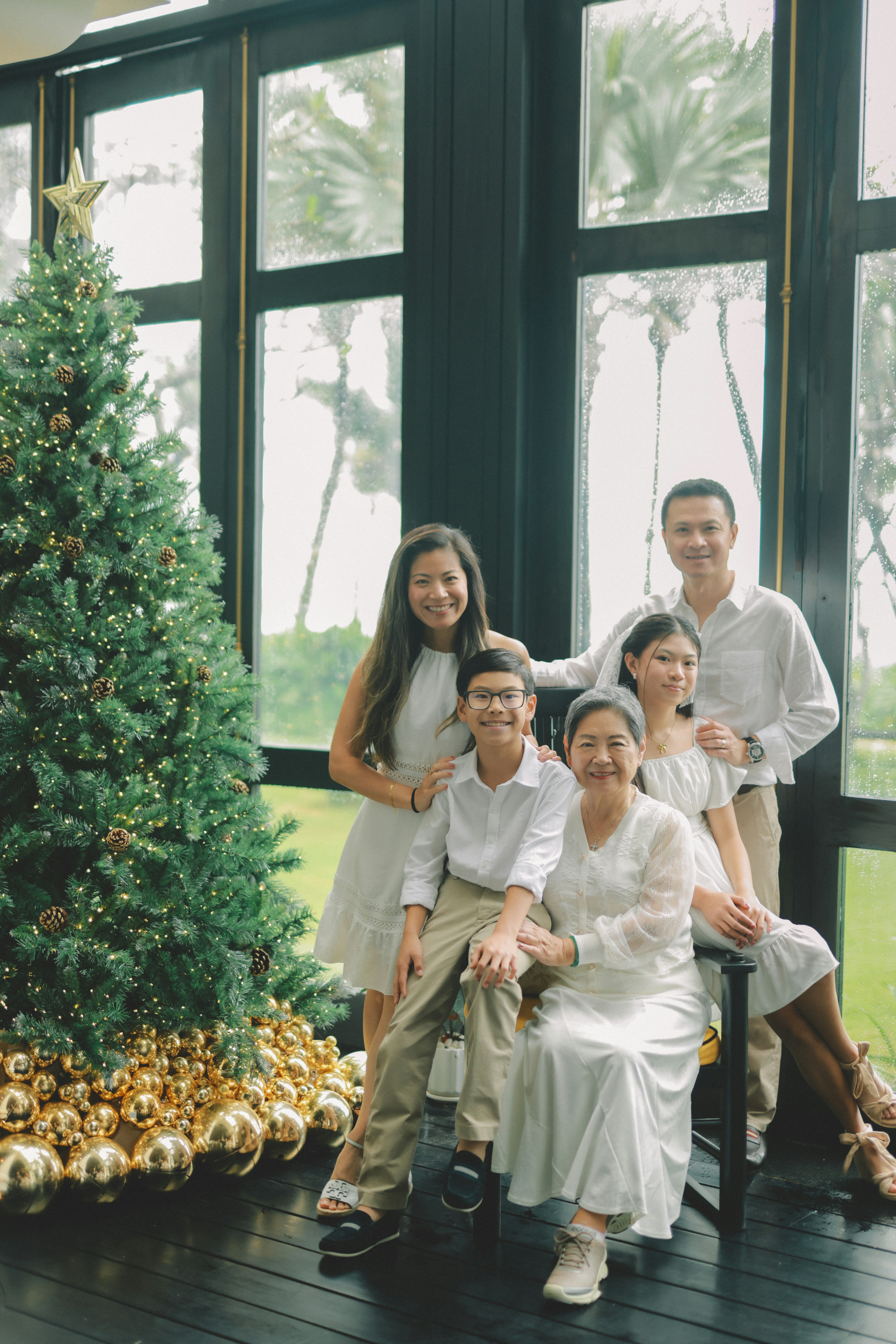 A family poses by a christmas tree.