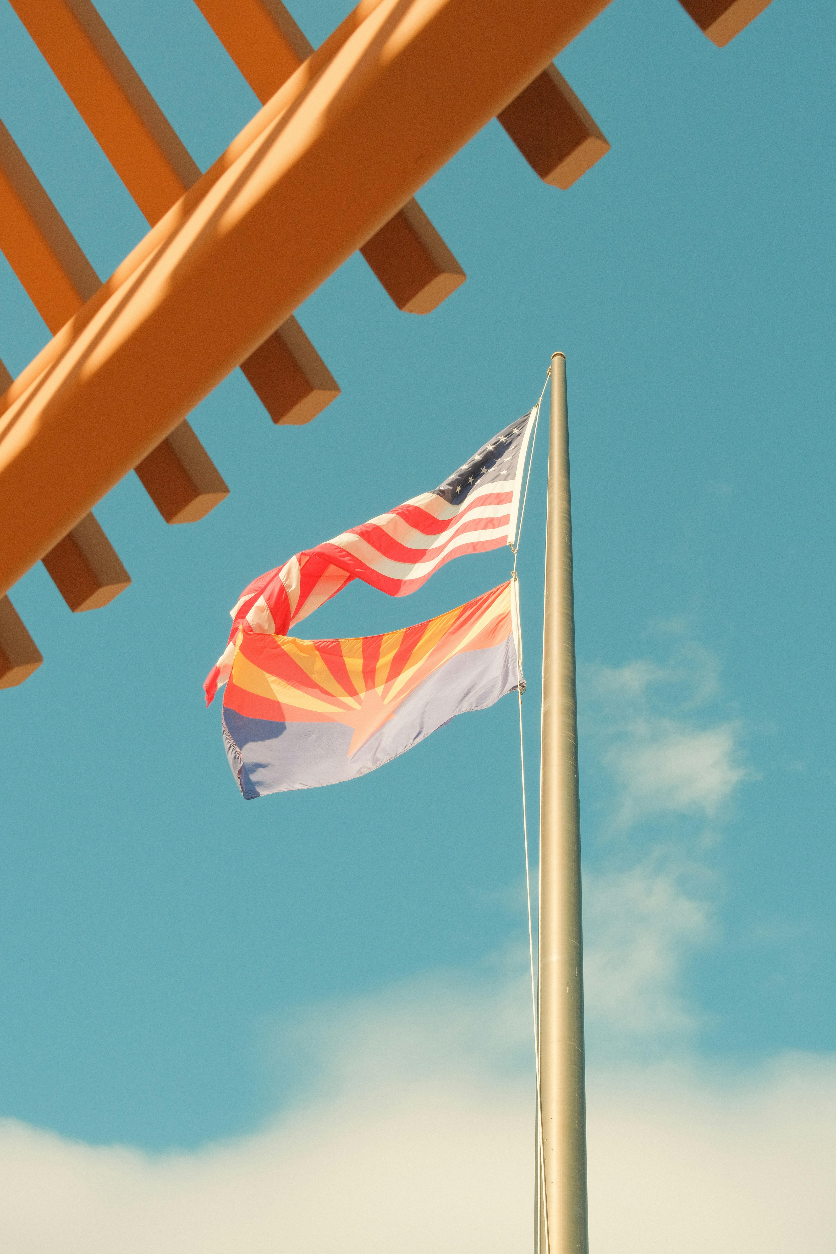 American and arizona flags waving on flagpole
