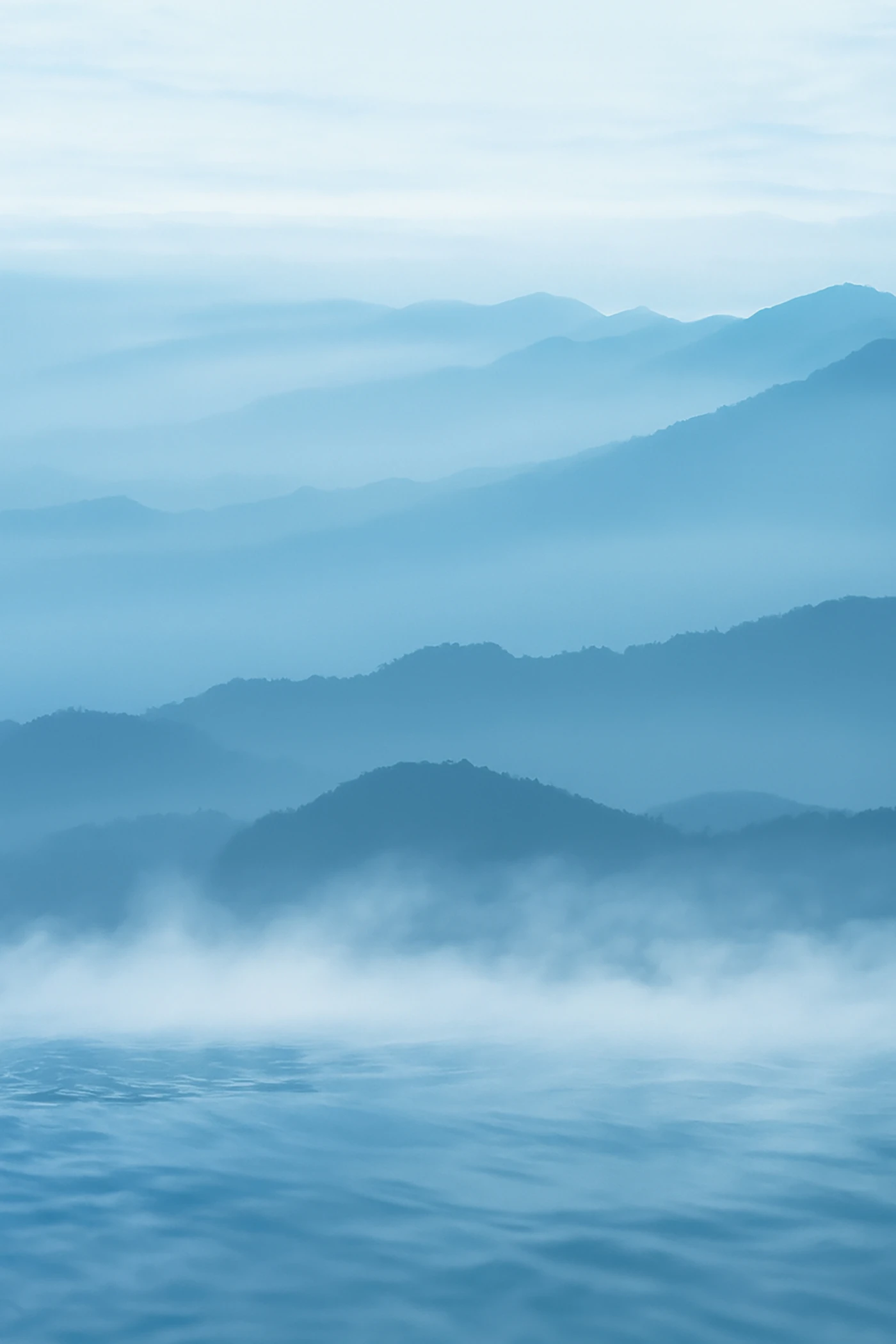 霧に包まれた青い山と静かな水面