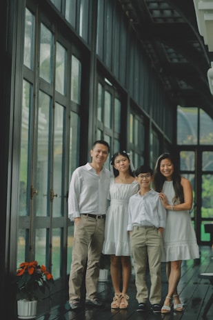 A family of four poses for a portrait indoors.