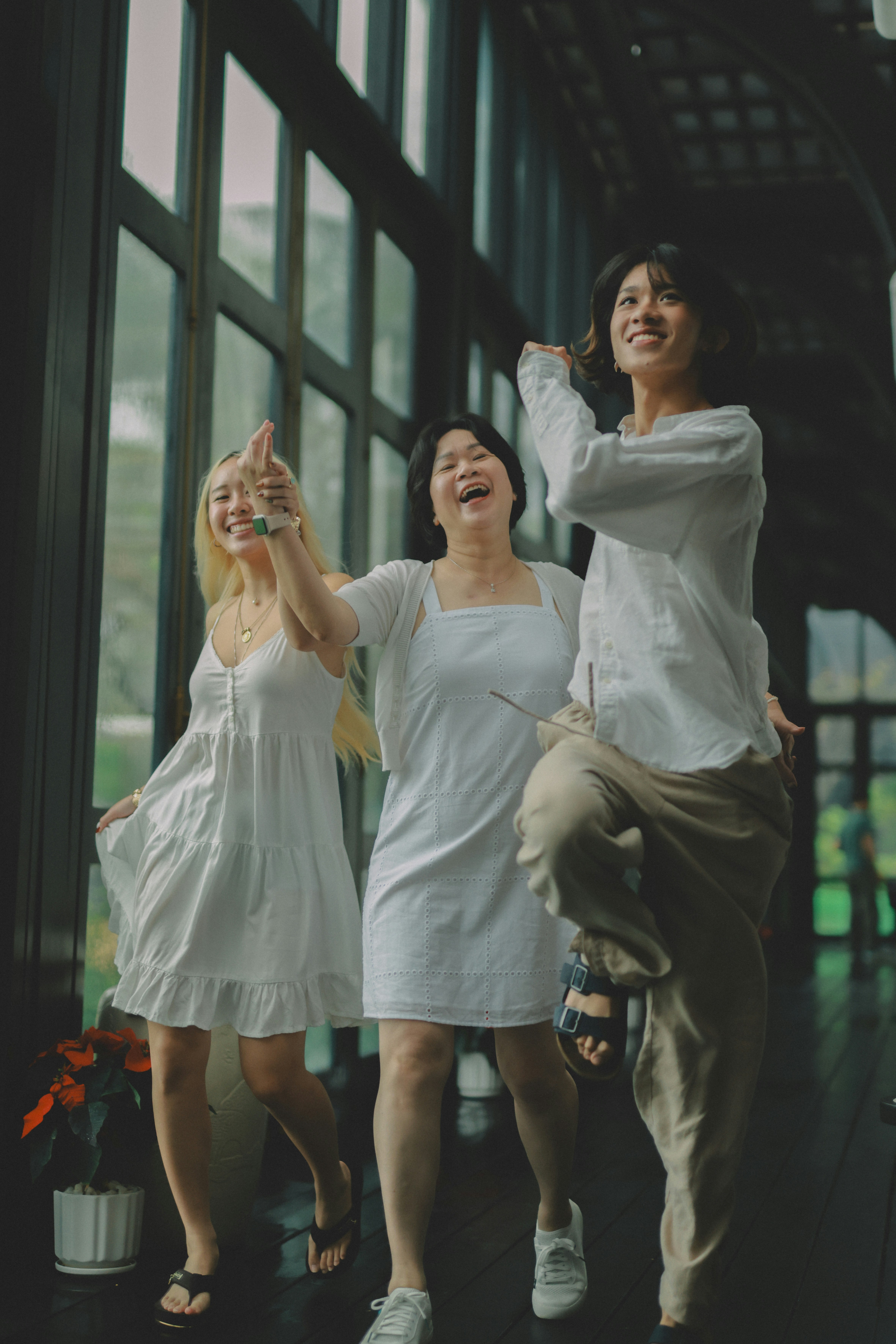 Tre donne in abiti bianchi che ballano e ridono