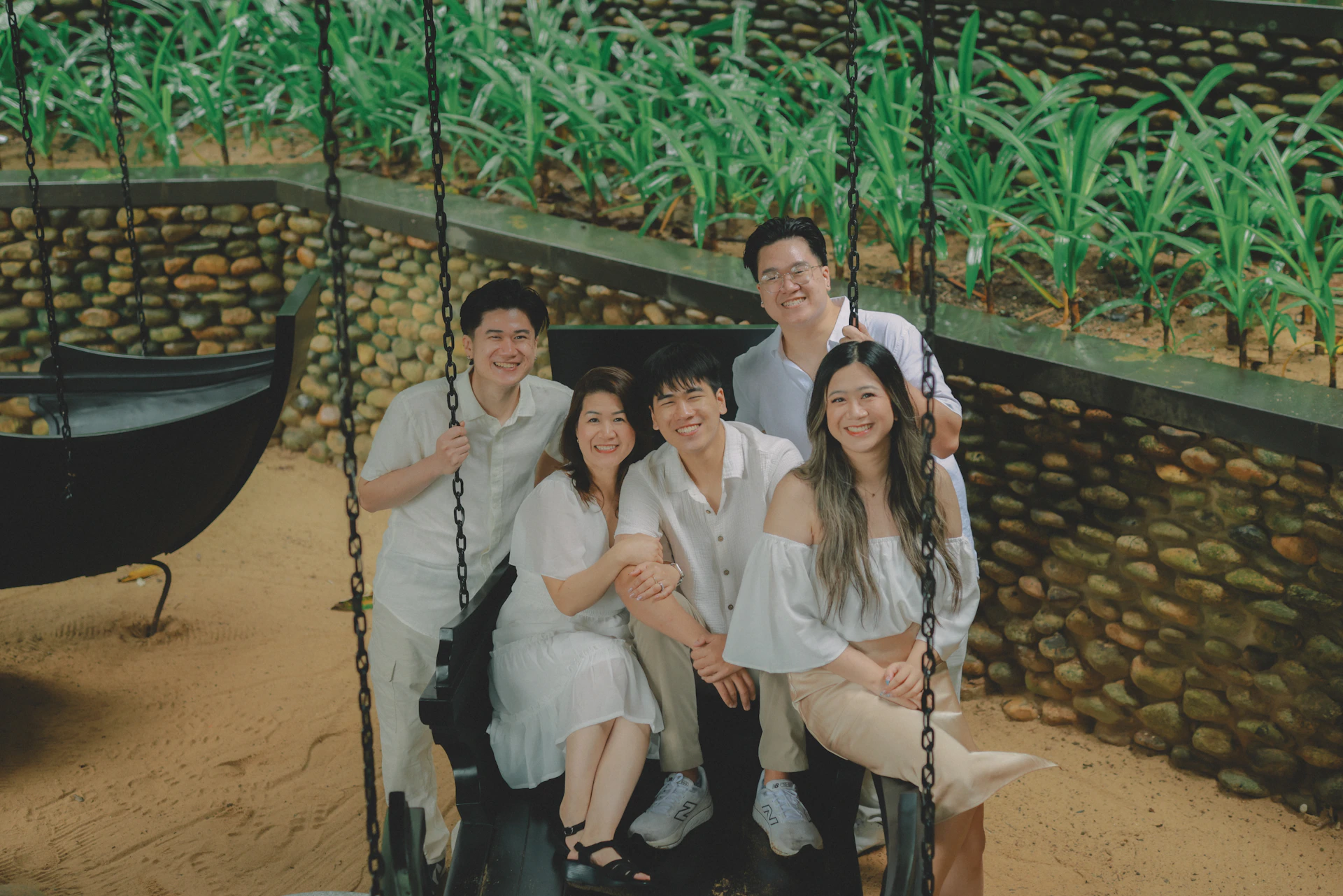 A family poses for a picture on a swing.