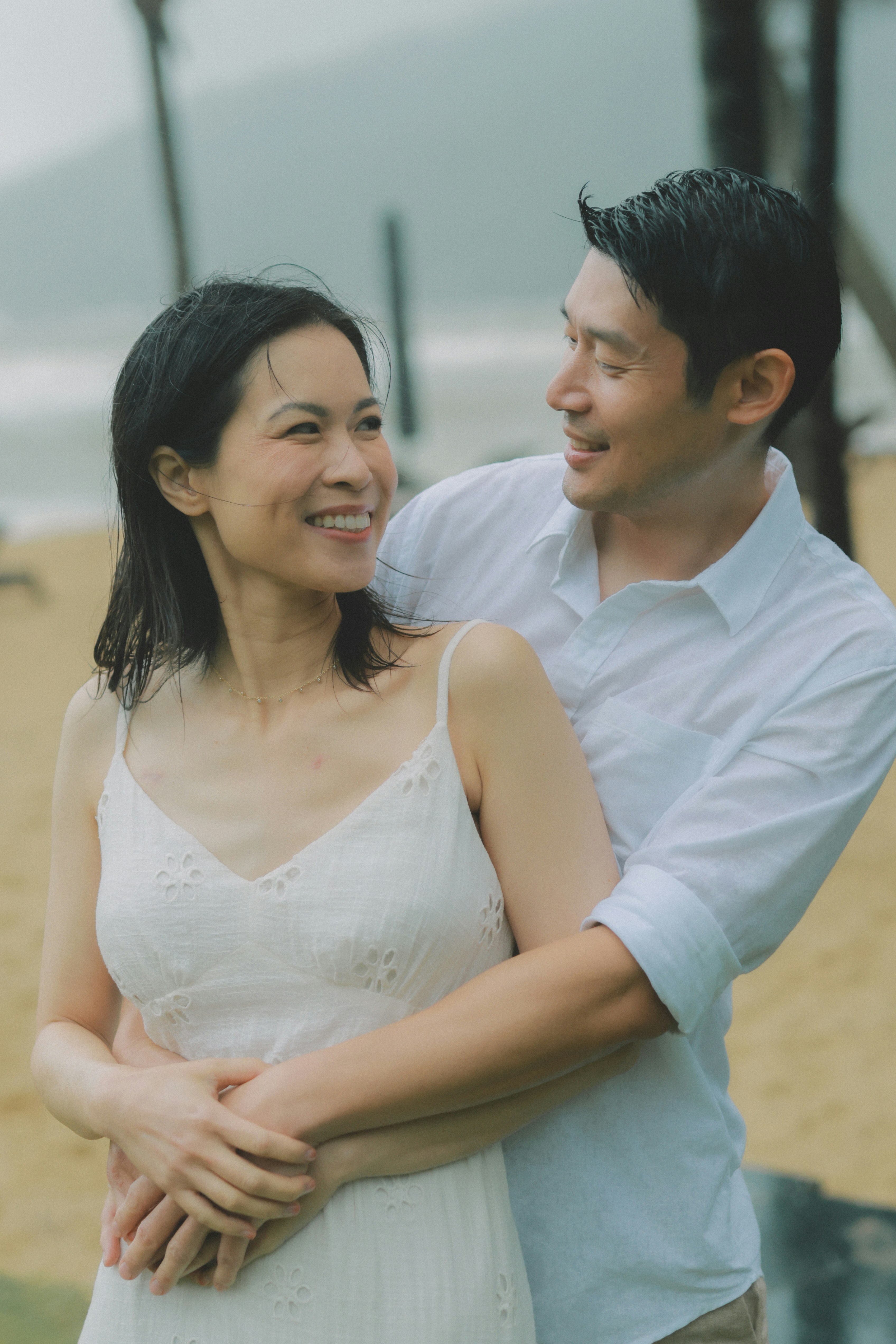 Couple embracing on a beach with ocean background