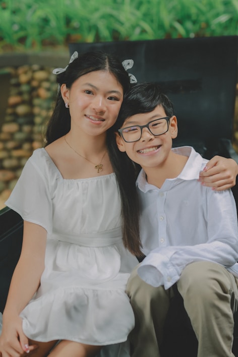 Two smiling children posing together outdoors.