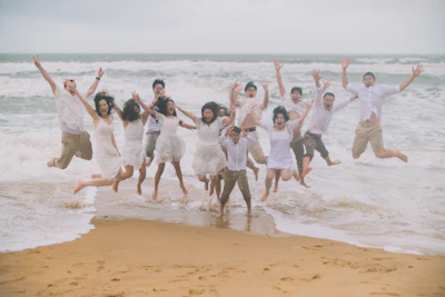 Group of people jumping joyfully on the beach.