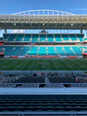 Empty stadium with green field and blue seats