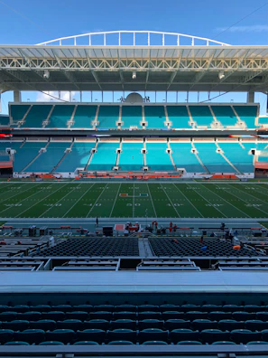 Empty stadium with green field and blue seats