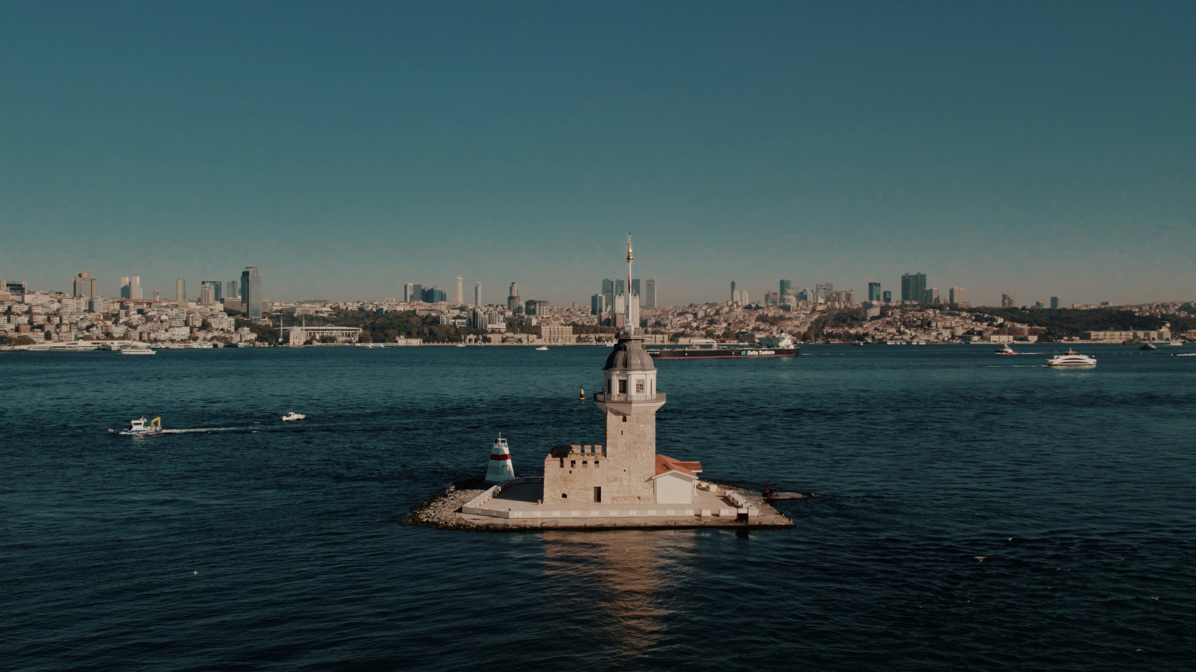 Historic maiden's tower in the sea with a city skyline.