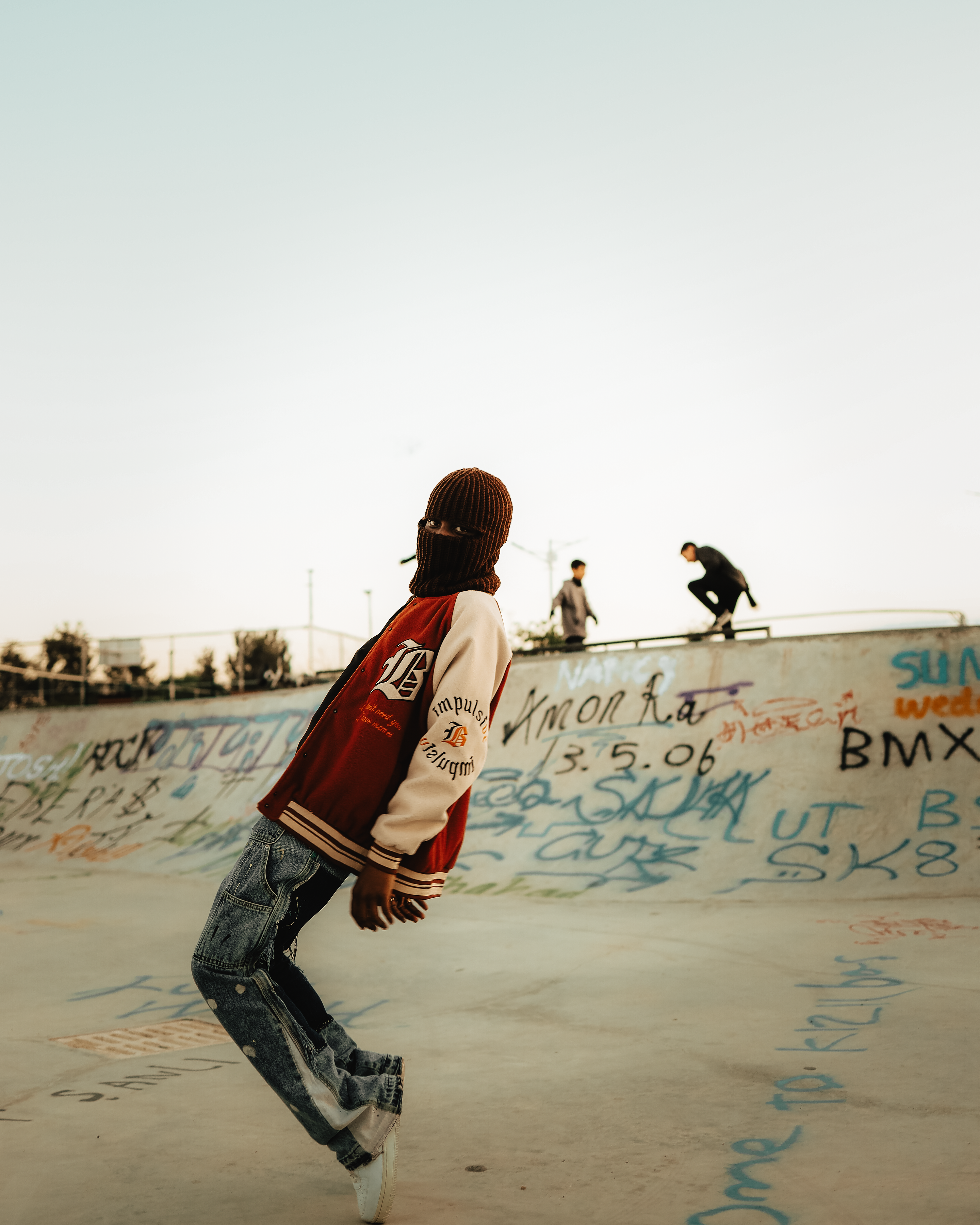 Teenagers skateboarding in a graffiti-covered skatepark