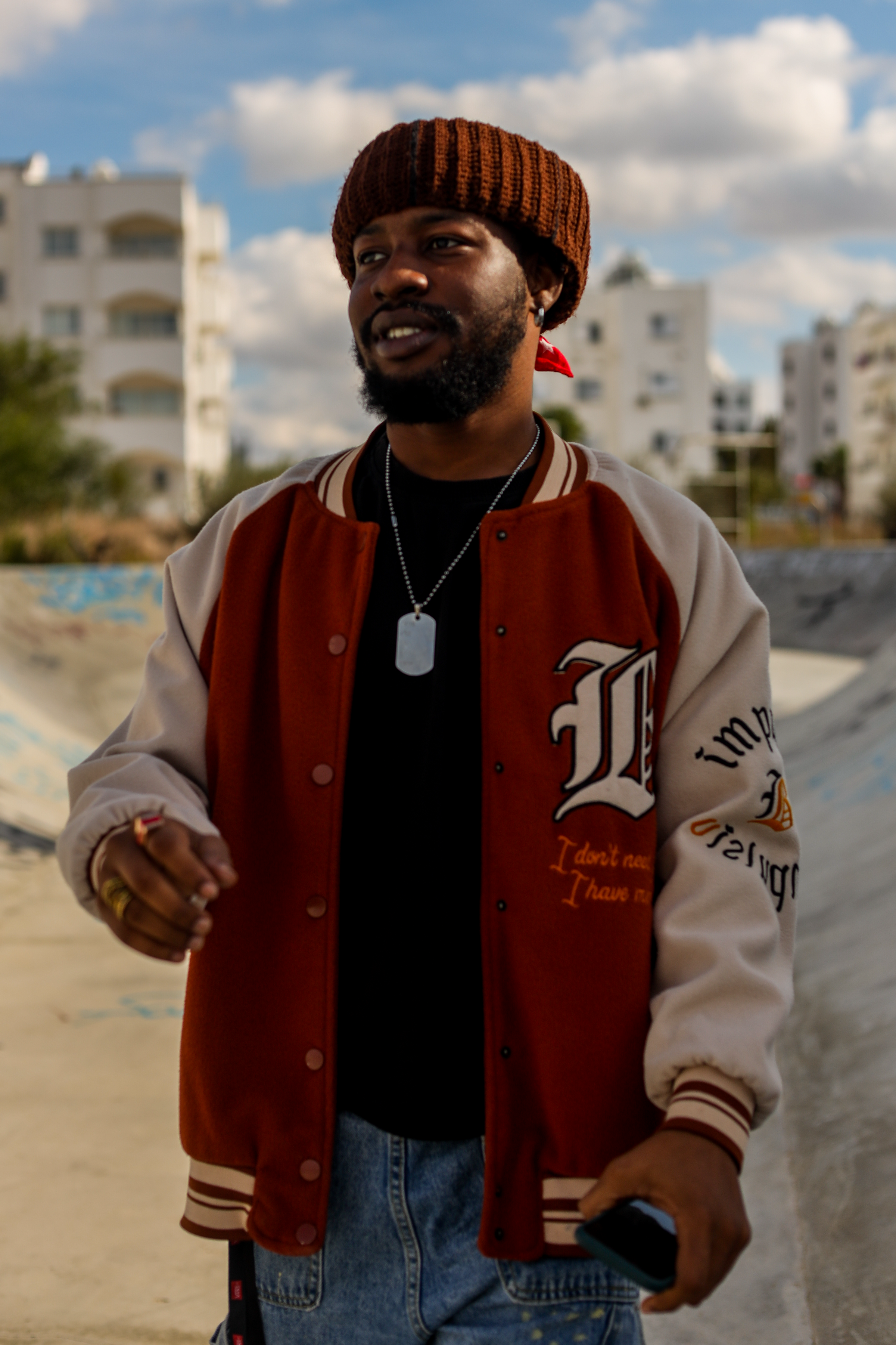 Hombre con chaqueta de letterman en el skate park