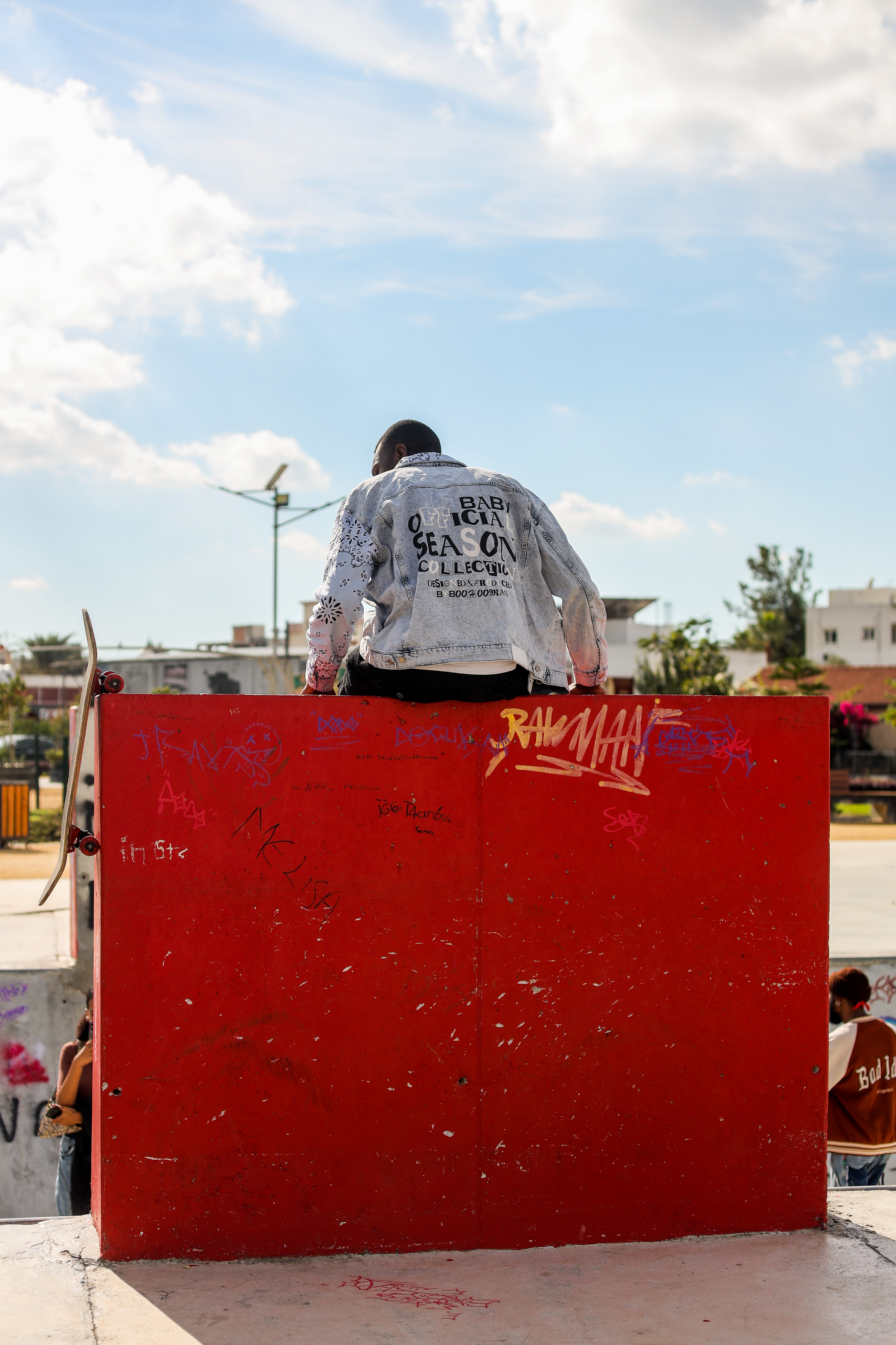 Skater sits on red ramp with skateboard