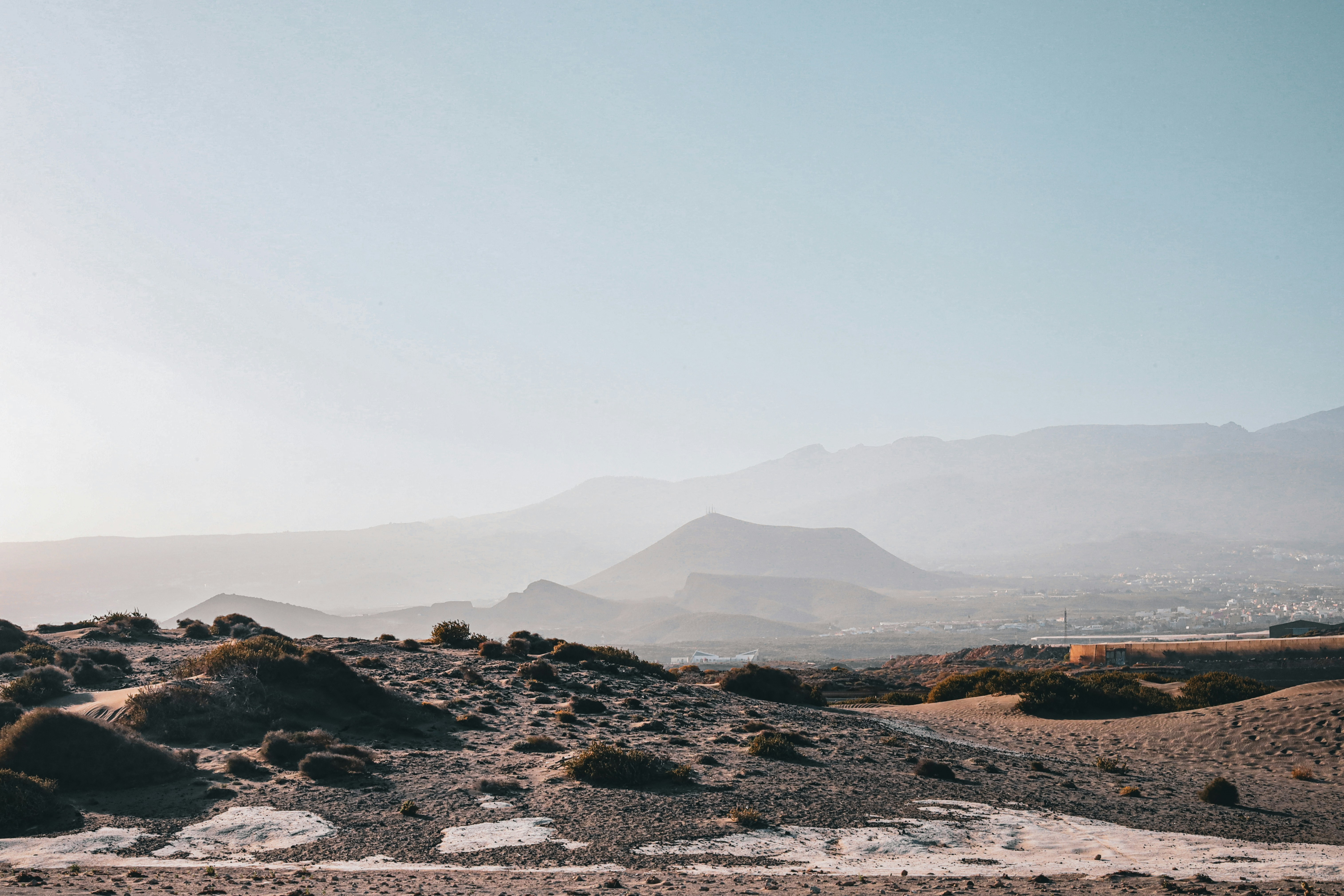Paesaggio montuoso nebbioso con cespugli secchi e sabbia
