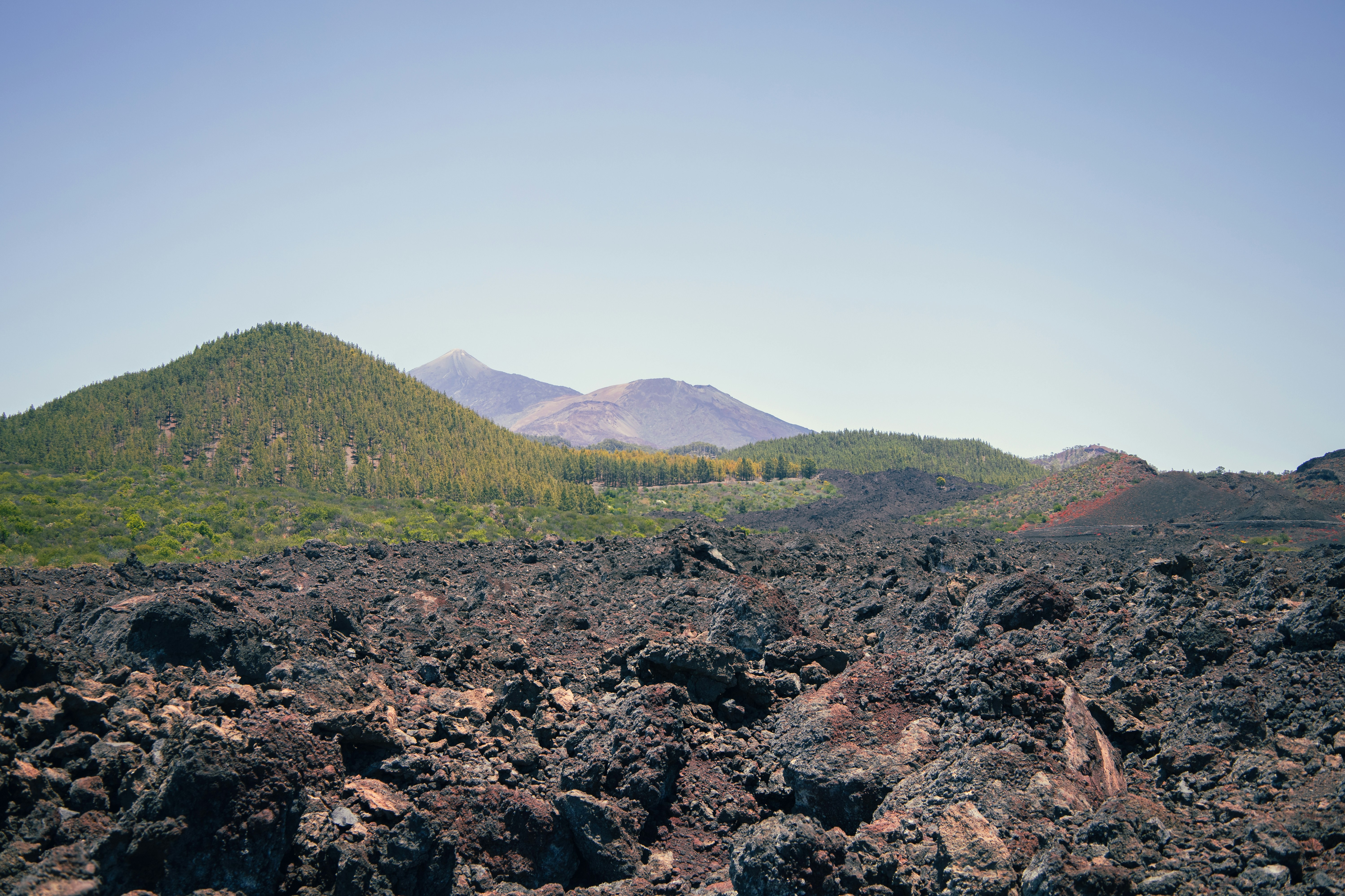 Paesaggio vulcanico roccioso con colline verdi e montagne