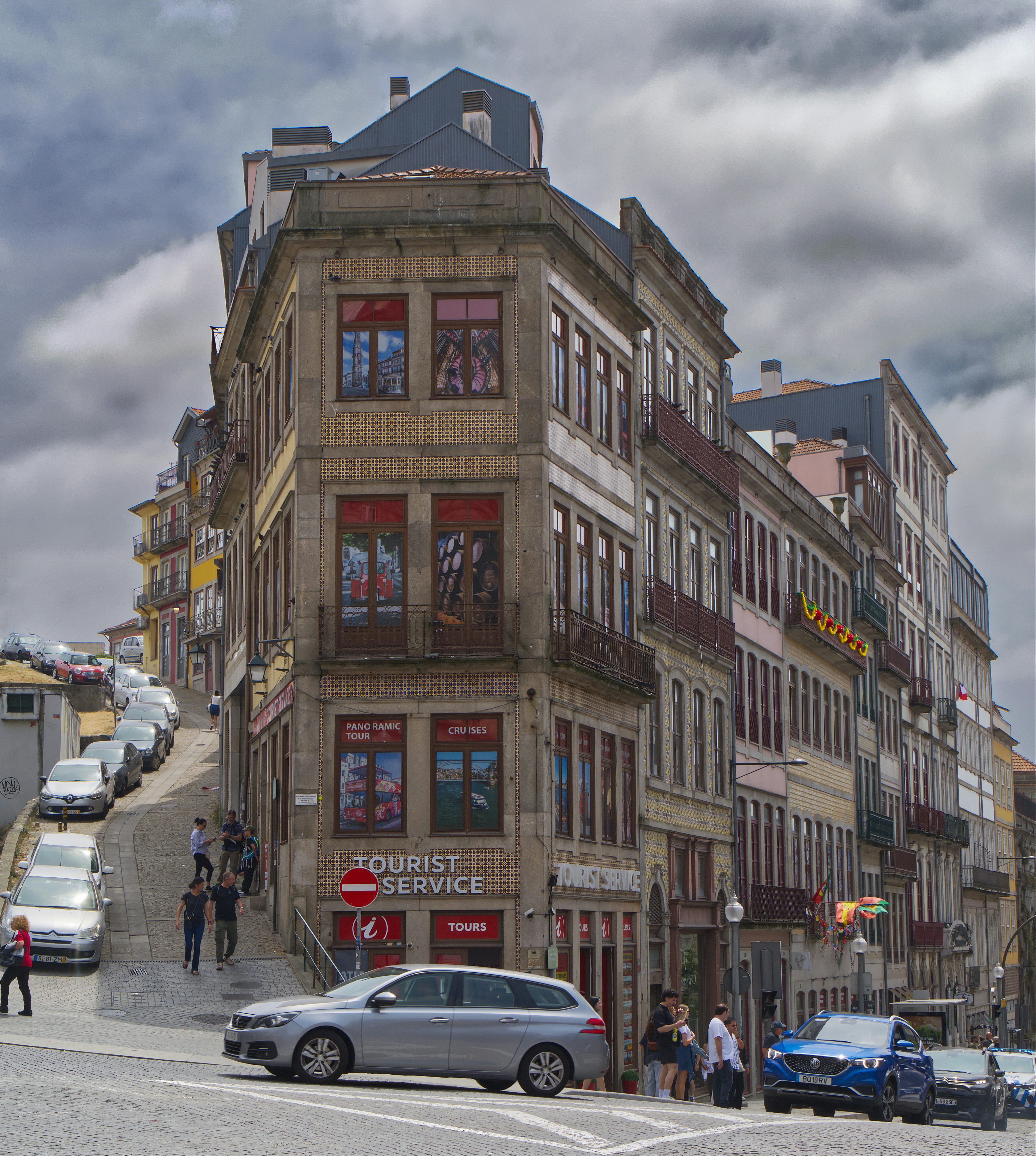 Edifícios históricos margeiam uma rua íngreme e estreita no Porto.