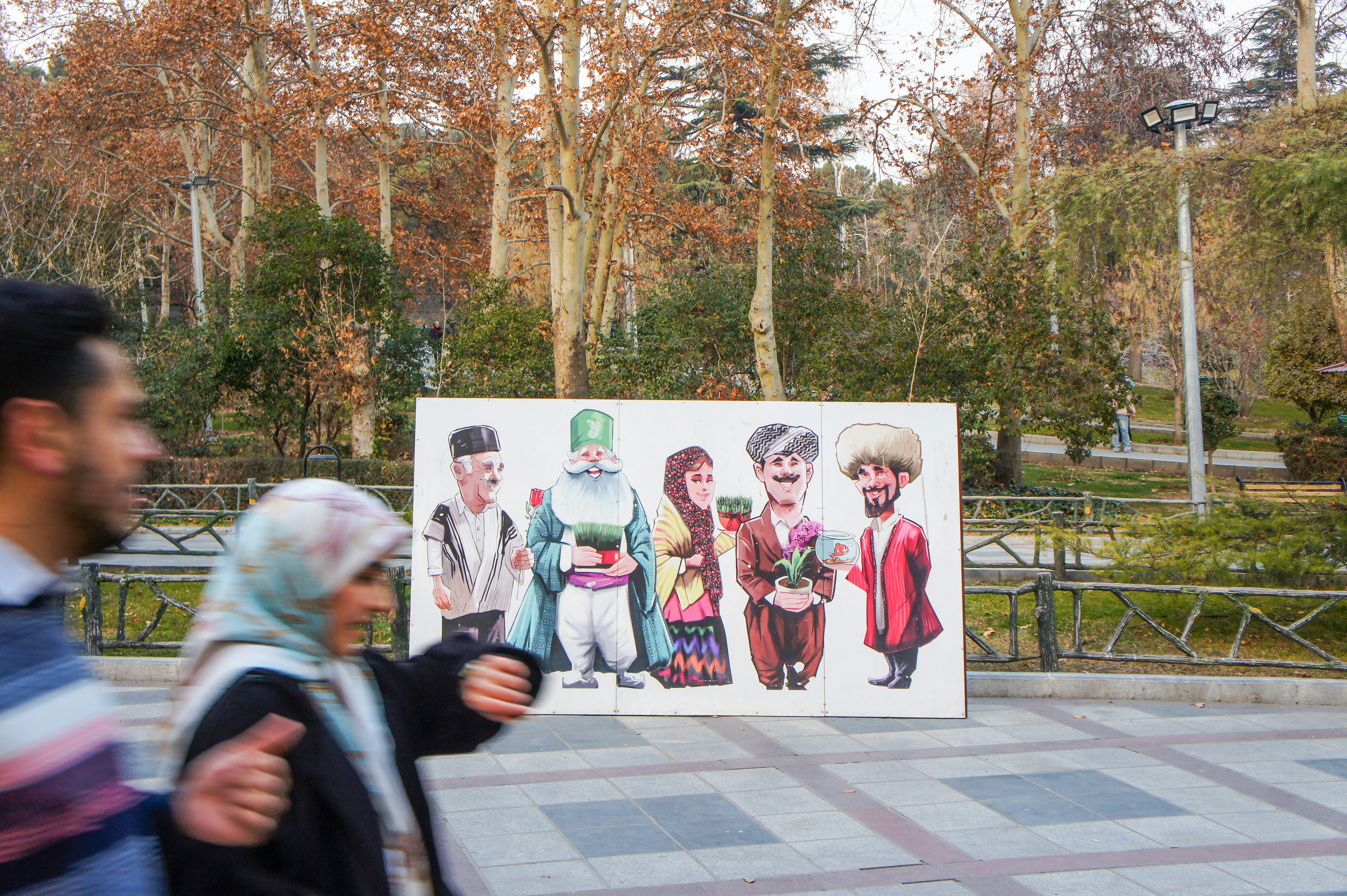 People walk past a display of cartoon characters.