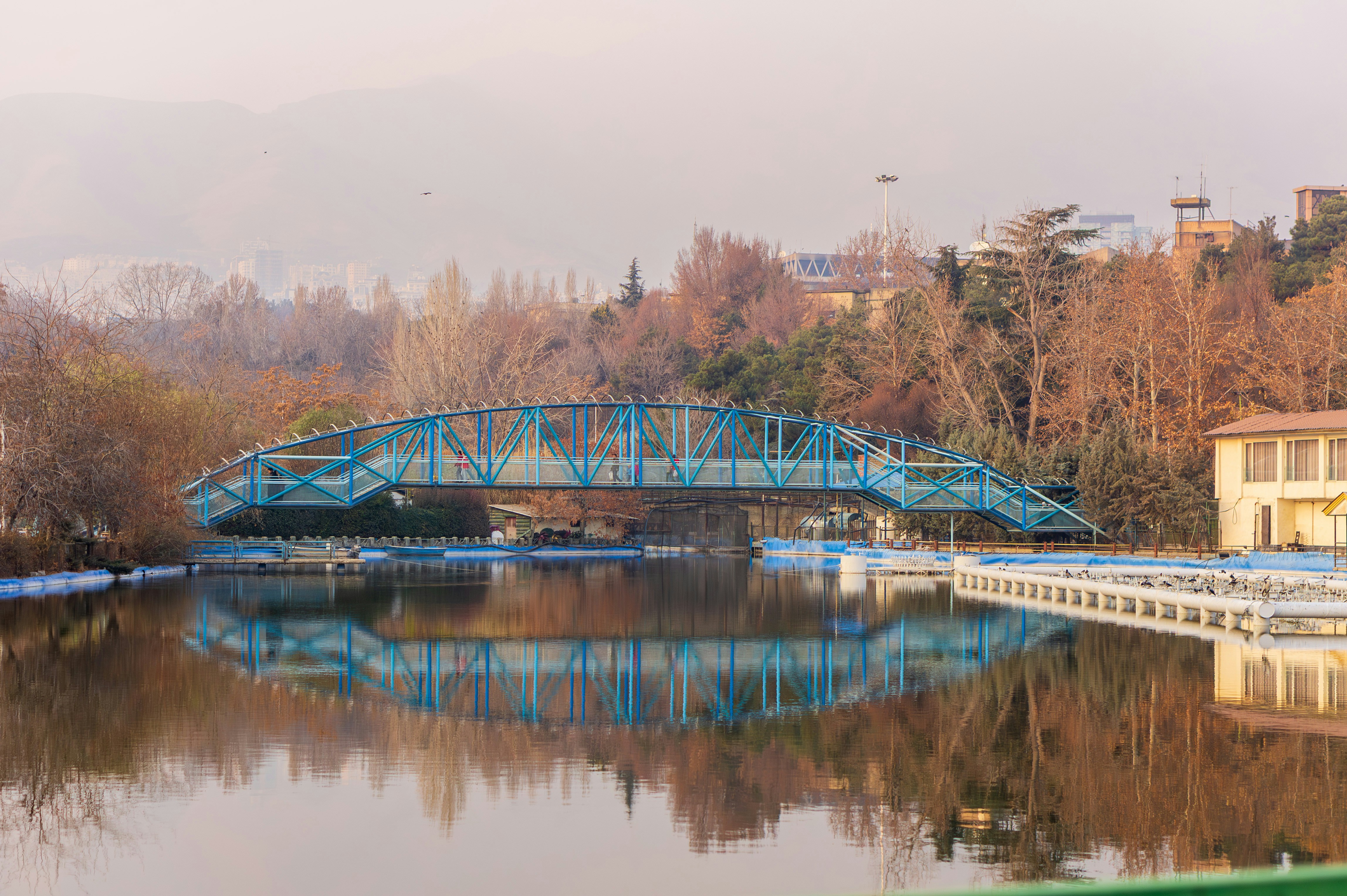 Blue arched bridge over calm water with reflections