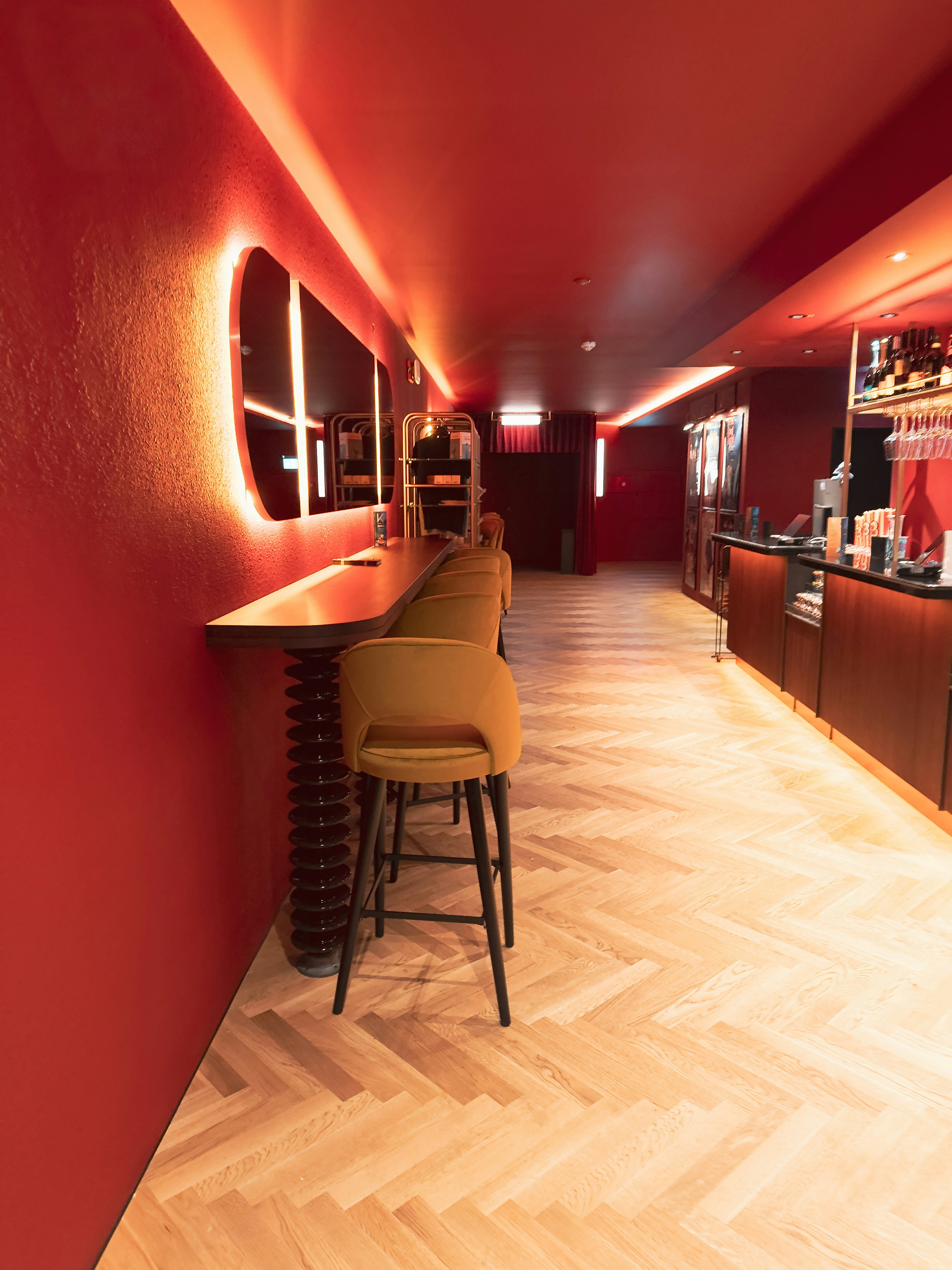 赤い壁と黄色いスツールを備えた現代的なバーの内装