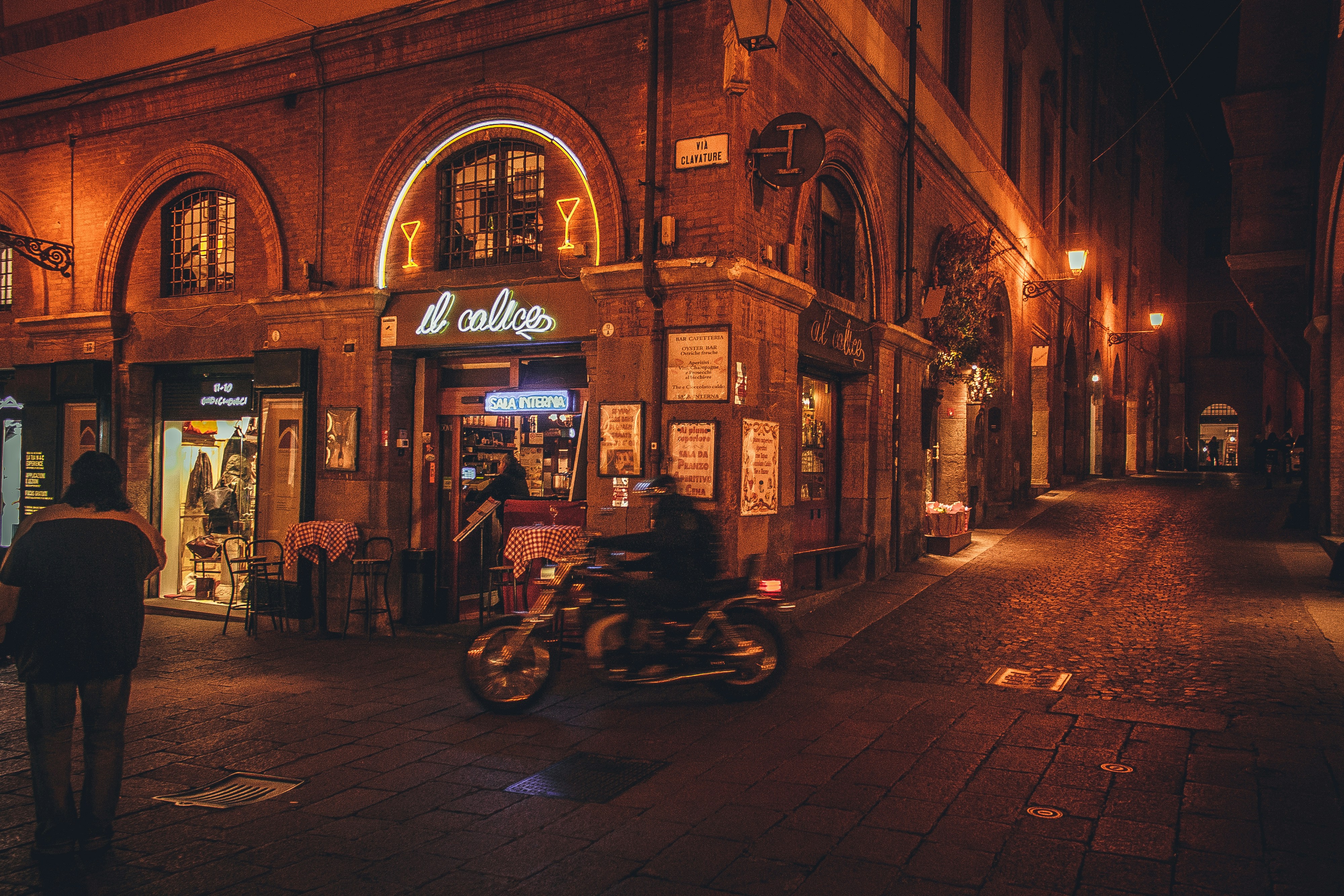 Motorcycle parked outside a dimly lit bar at night.