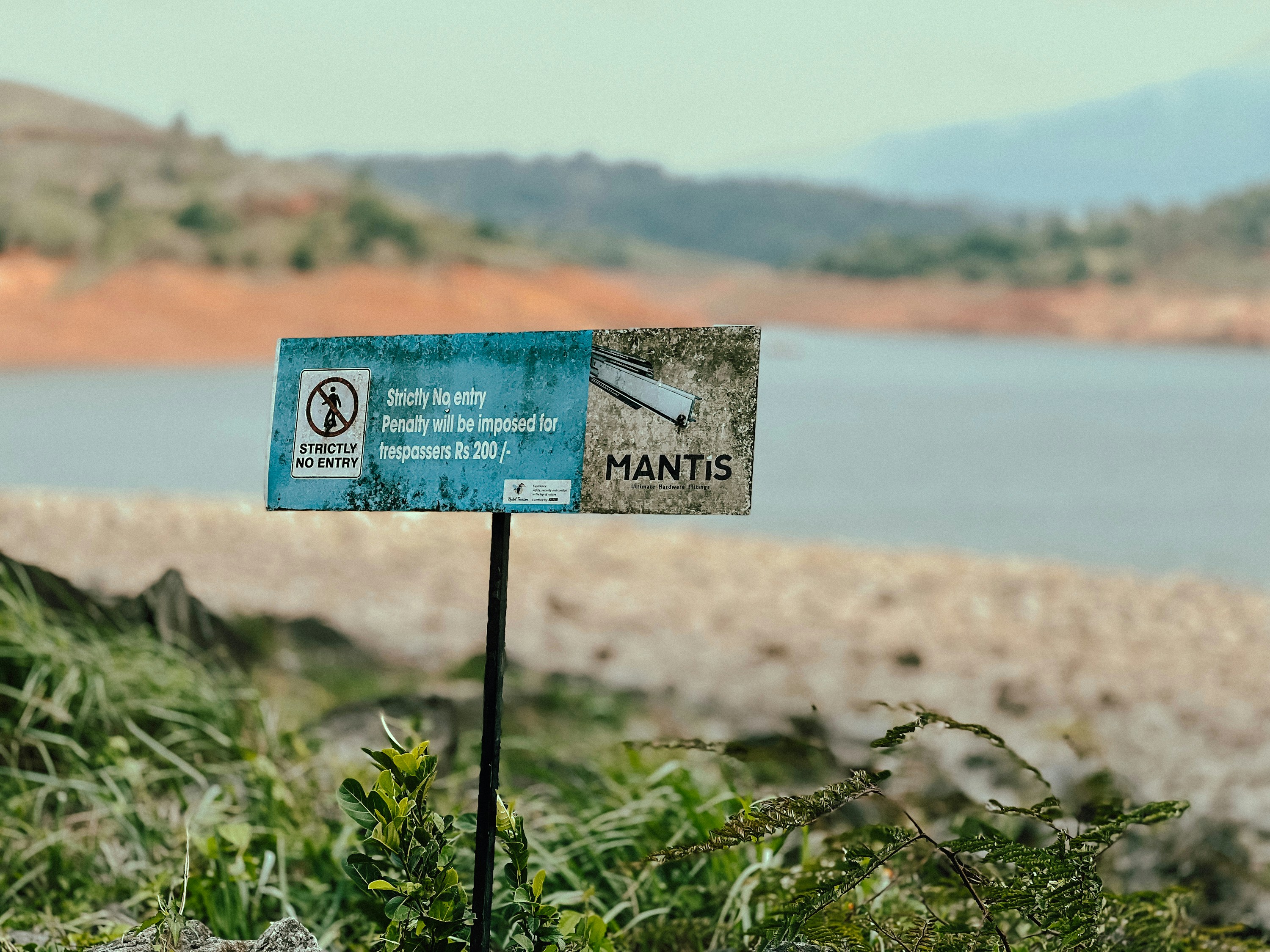 Cartel cerca de un cuerpo de agua con colinas