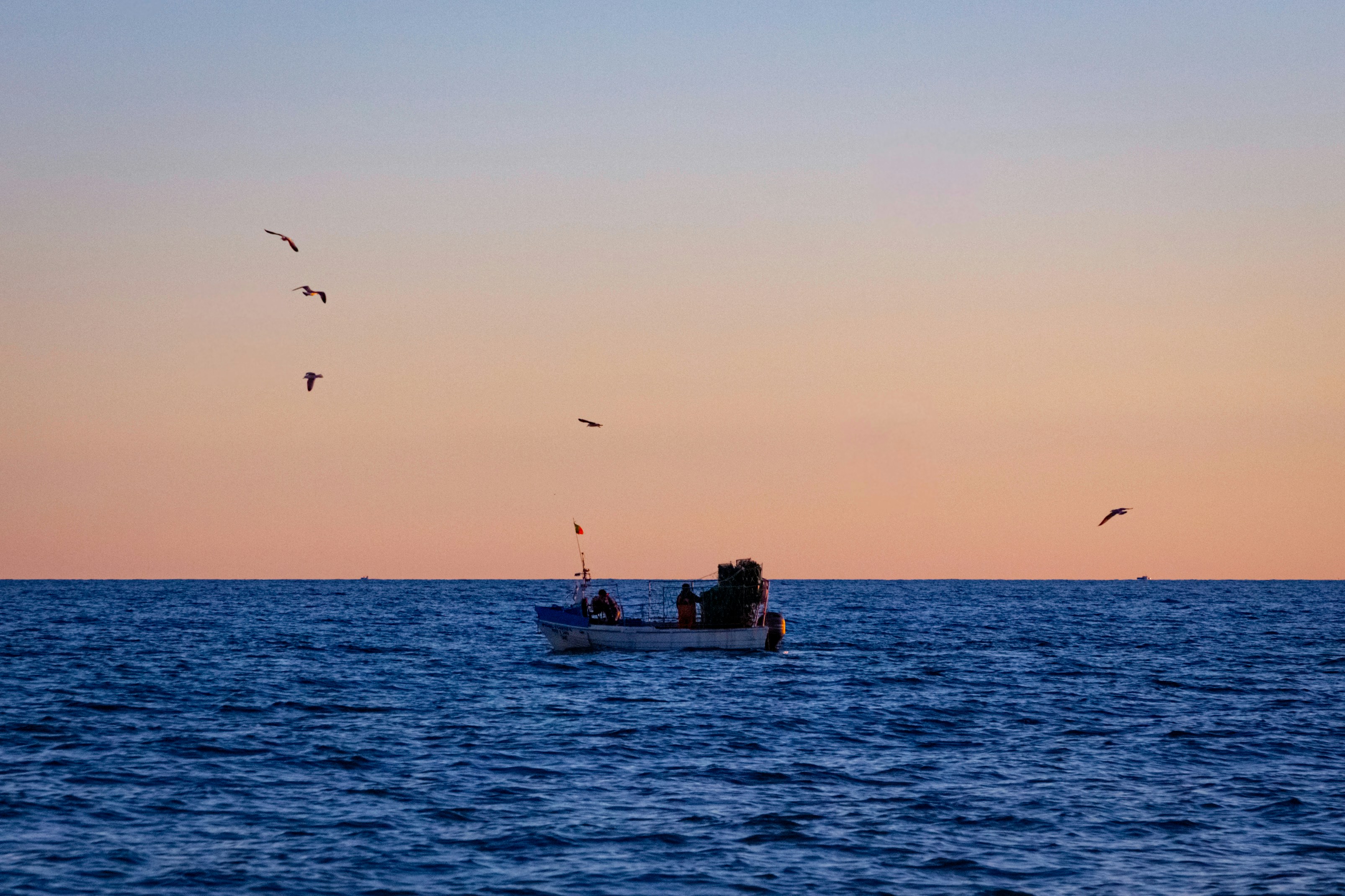 Bote de pesca al atardecer como referencia temática del juego