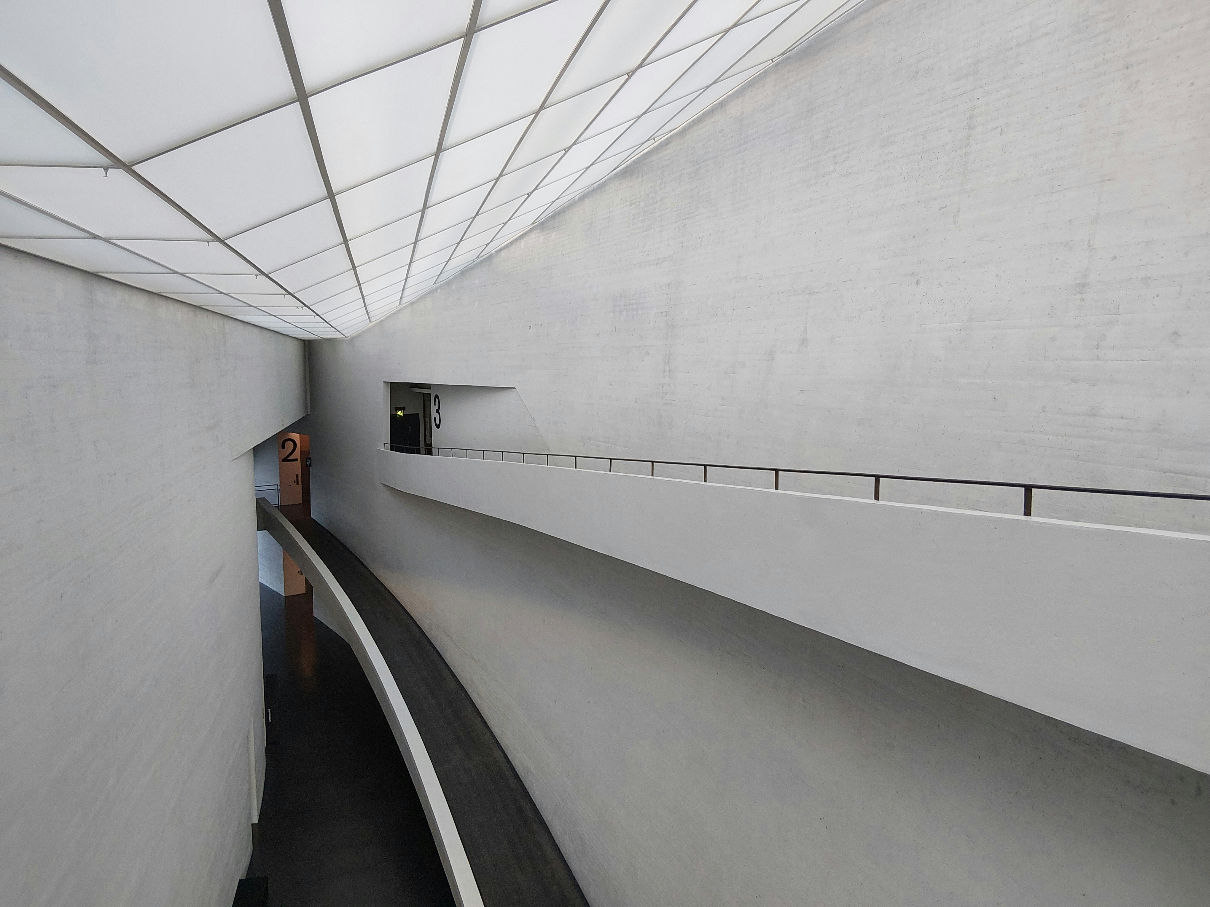 Modern concrete hallway with geometric ceiling